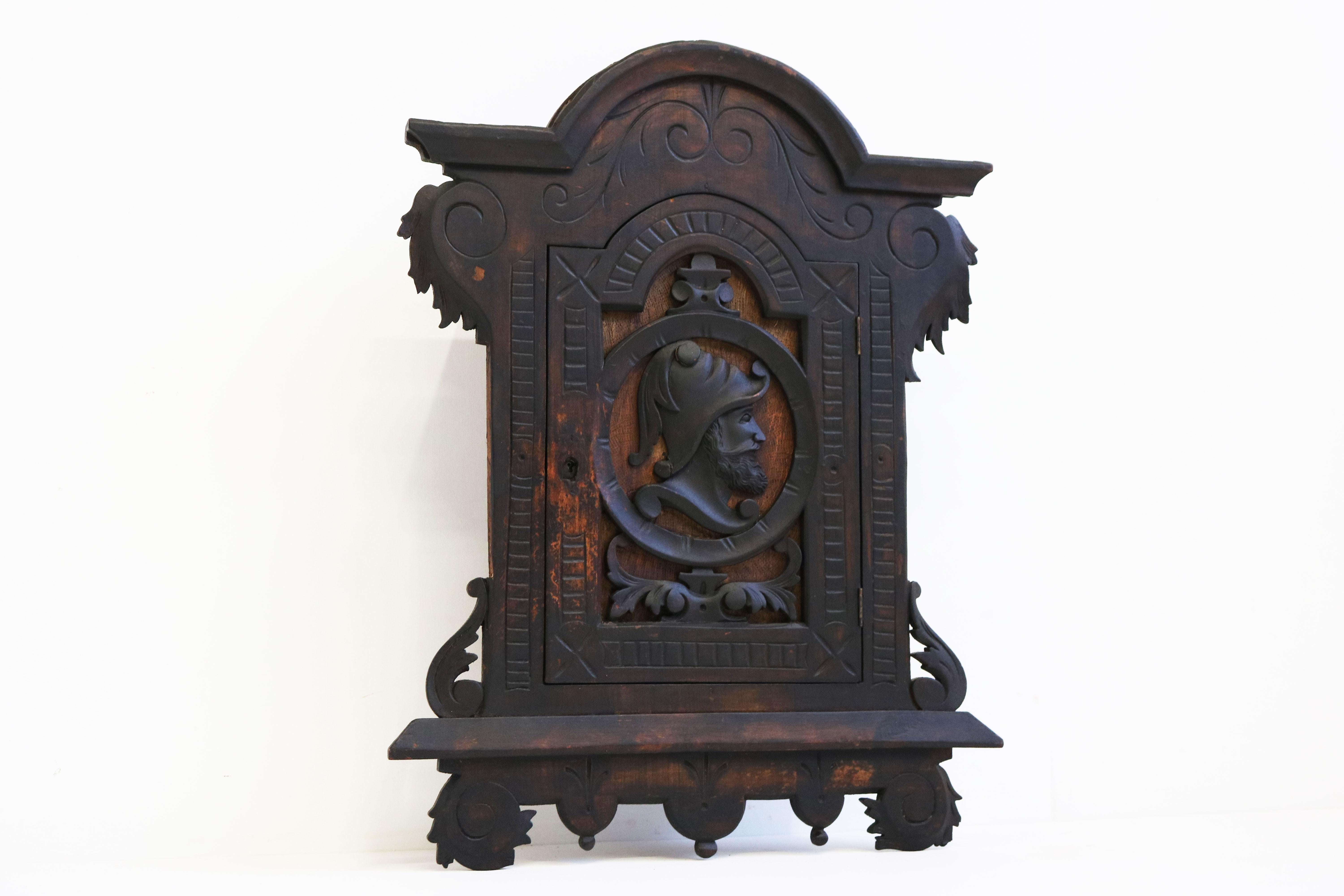 Exquisite 19th century Spanish colonial wall cabinet with a striking dark patina & carved knight.
Very nice small antique that brings the right charm & vibe to any room. 
The interior has 4 compartments for storage. 
The cabinets door is richly