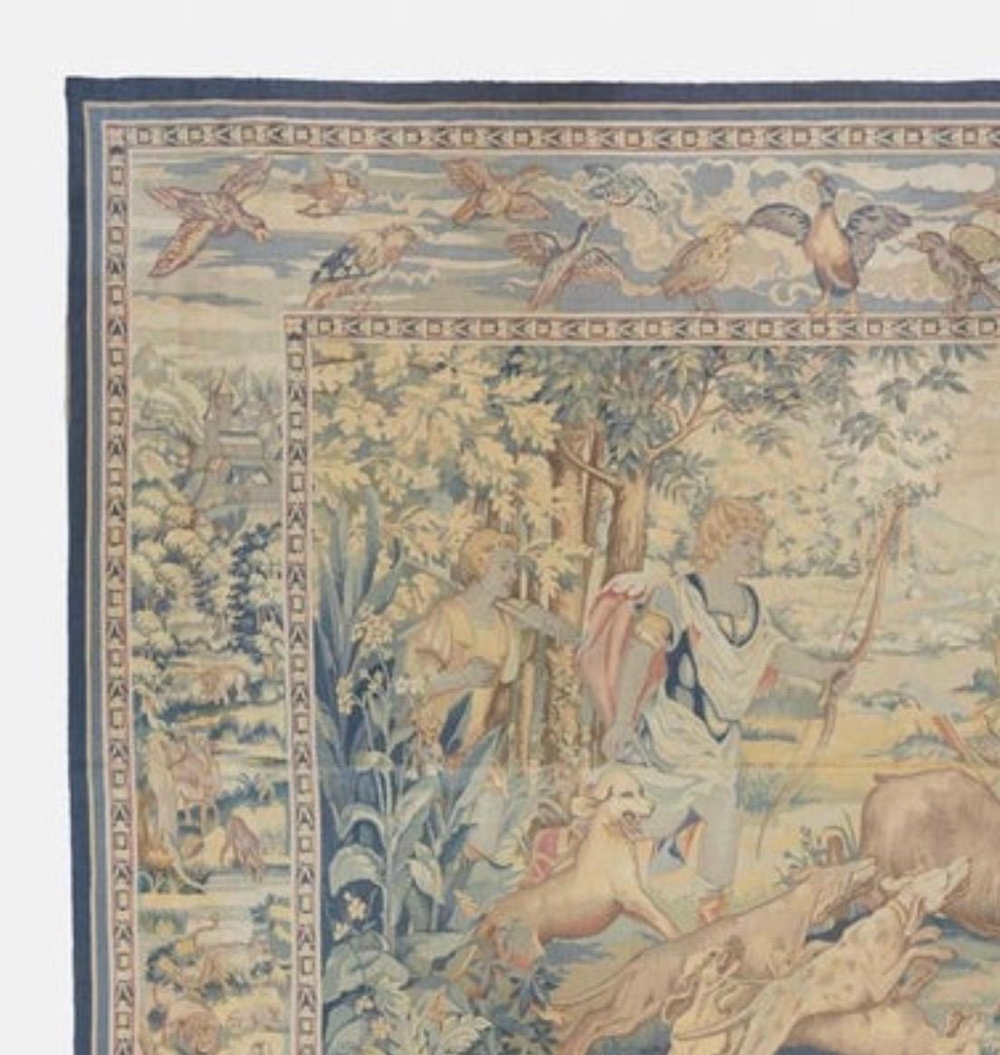 This is a lovely antique 19th Century Square French Aubusson Tapestry depicting a Hunting Scene on a beautiful summer day in the countryside with lush trees and vegetation. We see that an antelope has been struck with an arrow and the dogs have