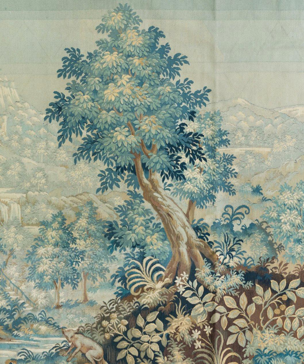 Il s'agit d'une très belle tapisserie ancienne du XIXe siècle en Verdure représentant une belle scène estivale d'une campagne avec des arbres et une végétation luxuriante, une rivière avec un pont en pierre et un chemin menant à un manoir dans le