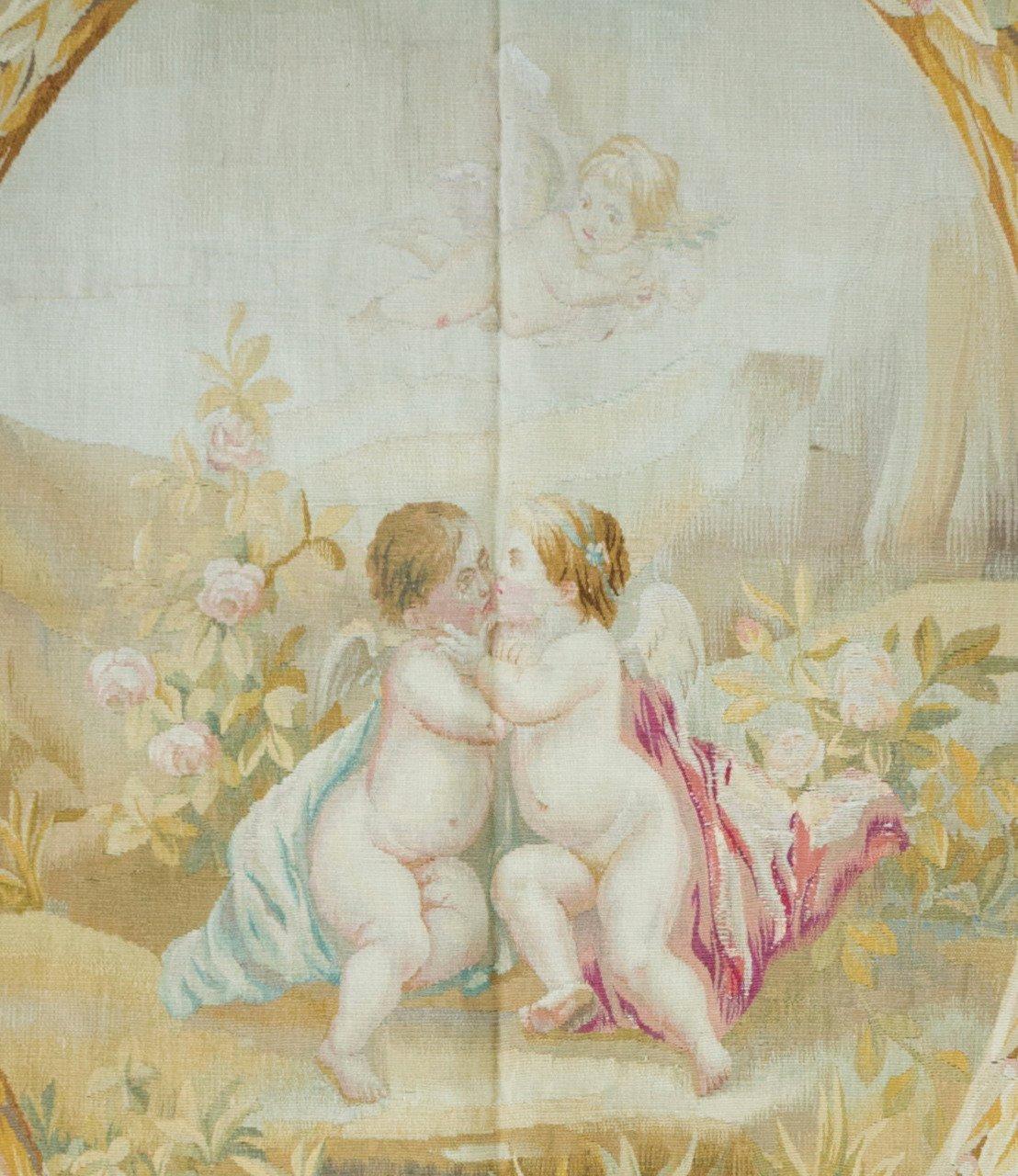 Il s'agit d'une très belle tapisserie d'Aubusson ancienne du 19ème siècle, de forme carrée, en ivoire et ornée de fleurs. Il est orné de guirlandes florales et d'une fenêtre ovale donnant sur une scène d'amour avec Cupidon volant au-dessus. Il est