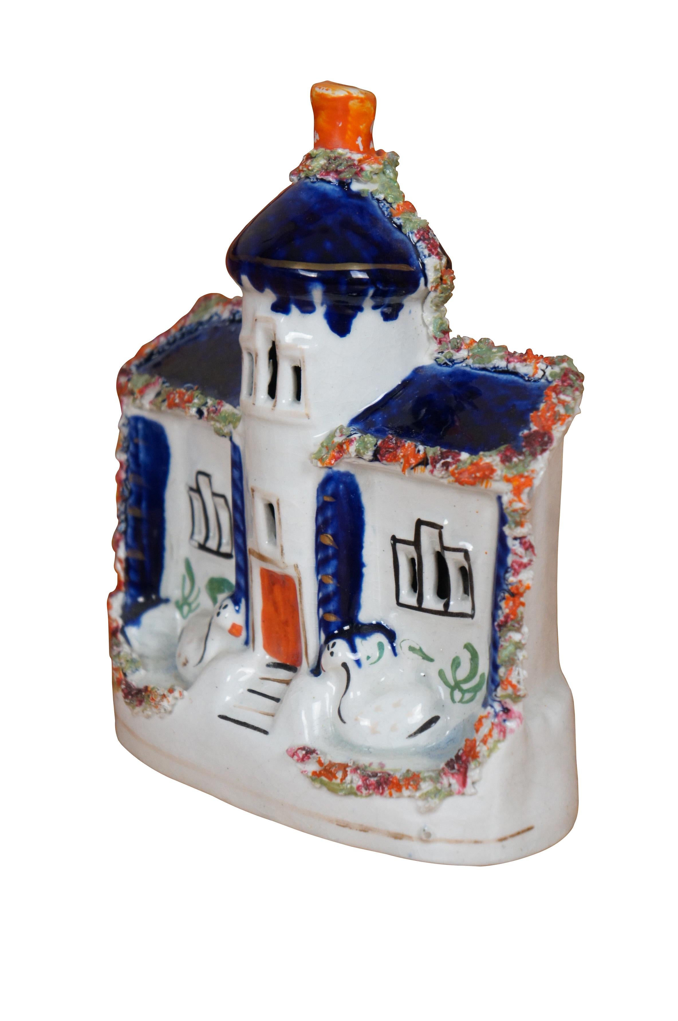 Antique 19th century Staffordshire porcelain flatback figurine in the shape of a white manor house / castle / cottage with central turret, cobalt blue columns and roof trimmed with flowers and a pair of swans seated in front.

Dimensions:
6