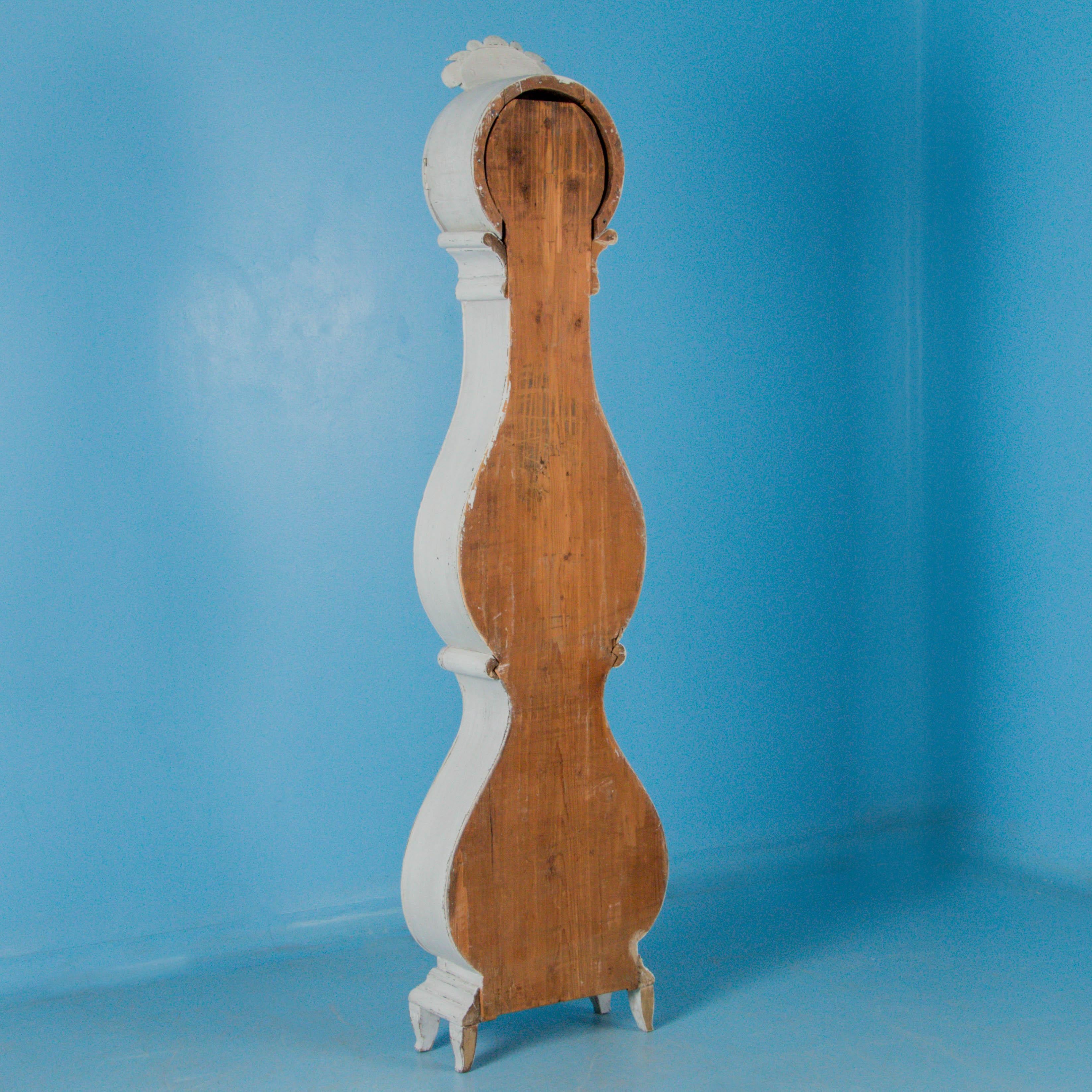 The off white painted finish compliments the Swedish styling of this grandfather clock from the famous region of Mora, Sweden. Please examine the close up photos to appreciate the painted finish with gentle distressing that was recently added, as