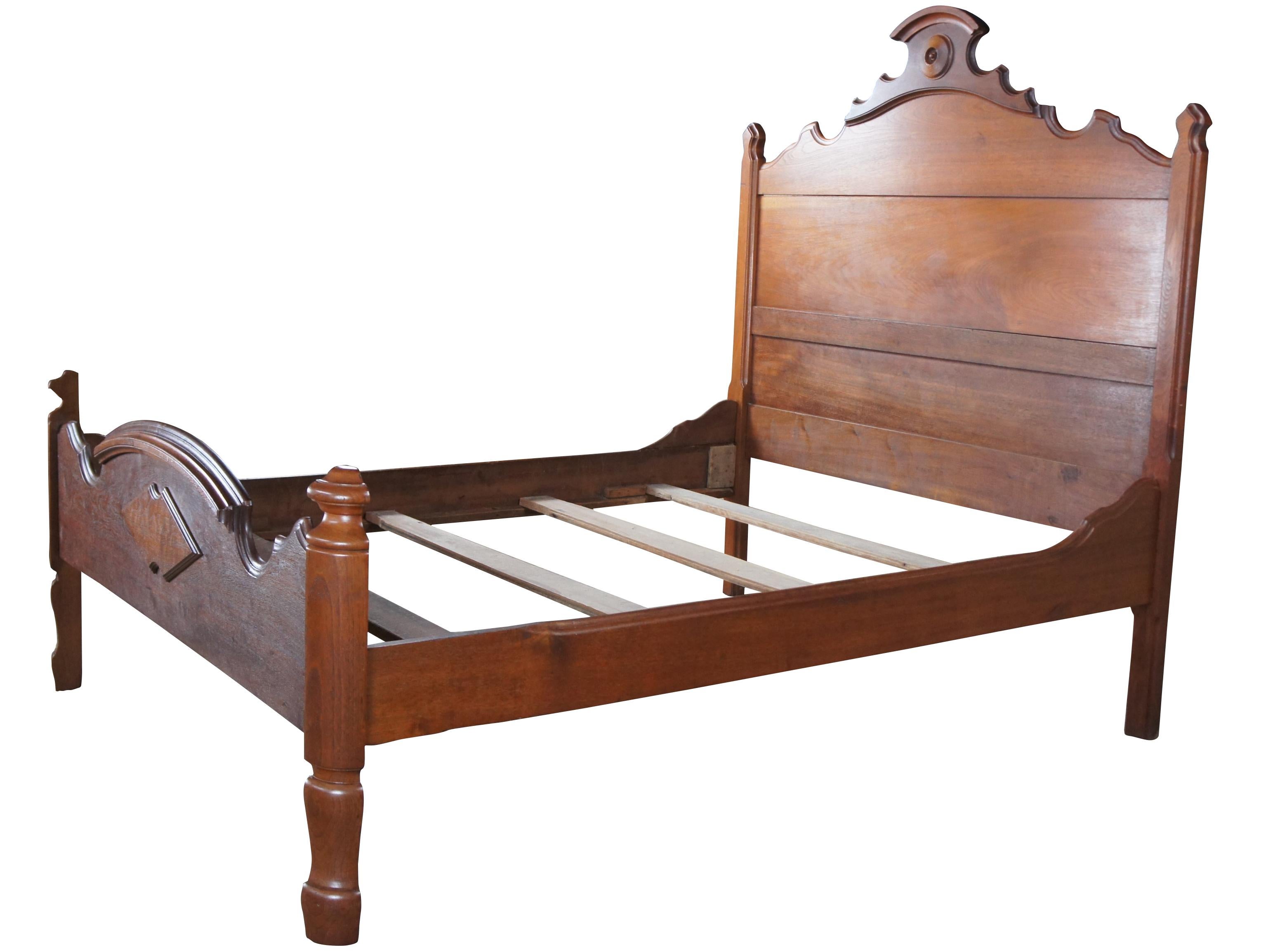 An antique Victorian era bed frame. Made from walnut with carved frame featuring embellishments along the headboard and foot board. 

Measures: 57