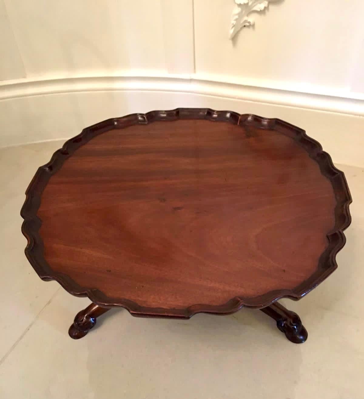 Antique 19th century Victorian Lazy Susan having a lovely revolving mahogany shaped top with pie crust edge. It is raised on an elegant carved turned column and supported by three carved shaped legs terminating on quality carved hoof feet.
  