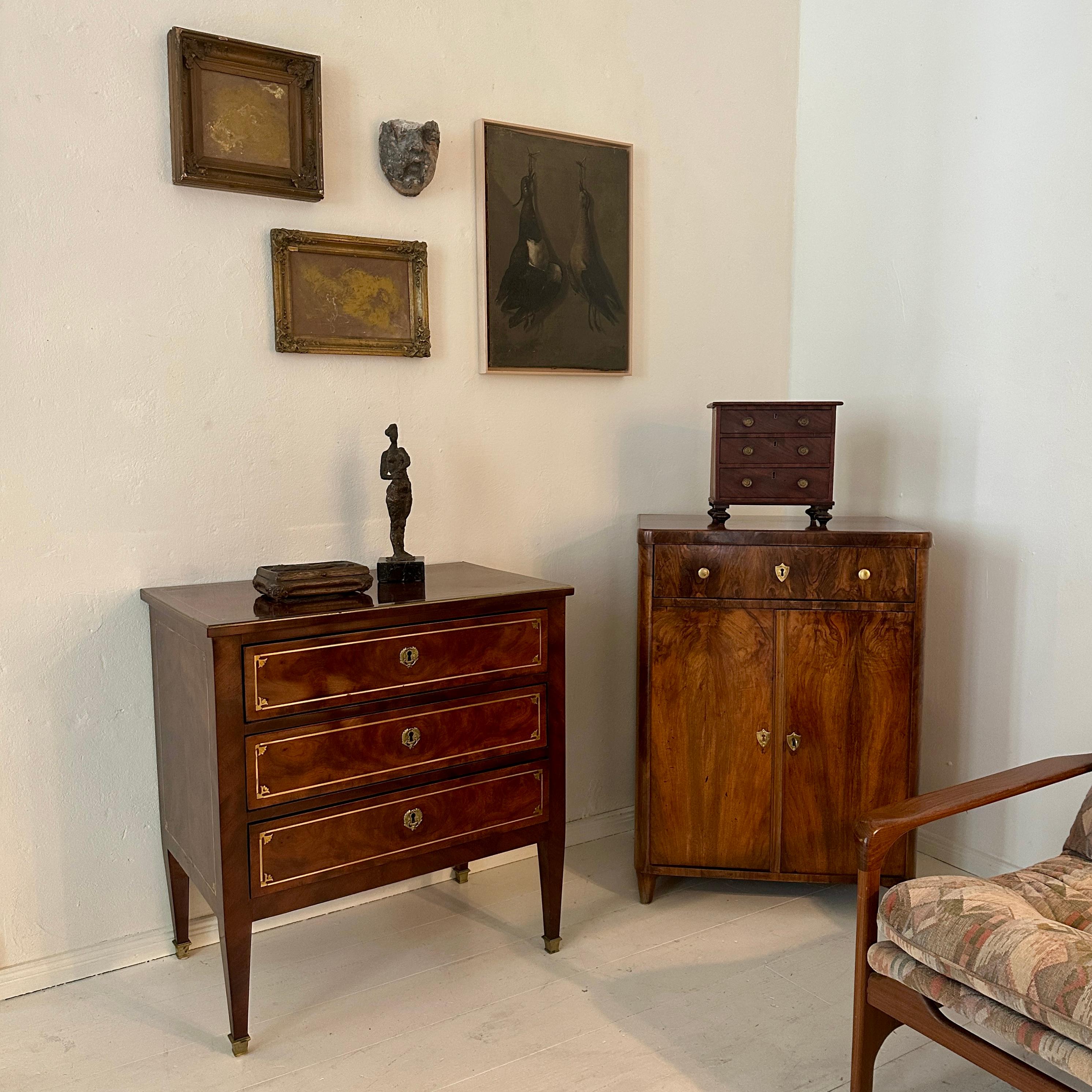 An exquisite 19th century Victorian miniature chest of drawers, finely crafted as both a decorative and collectible cabinet. Made with attention to detail, this charming piece features three drawers, each with original brass pulls and central
