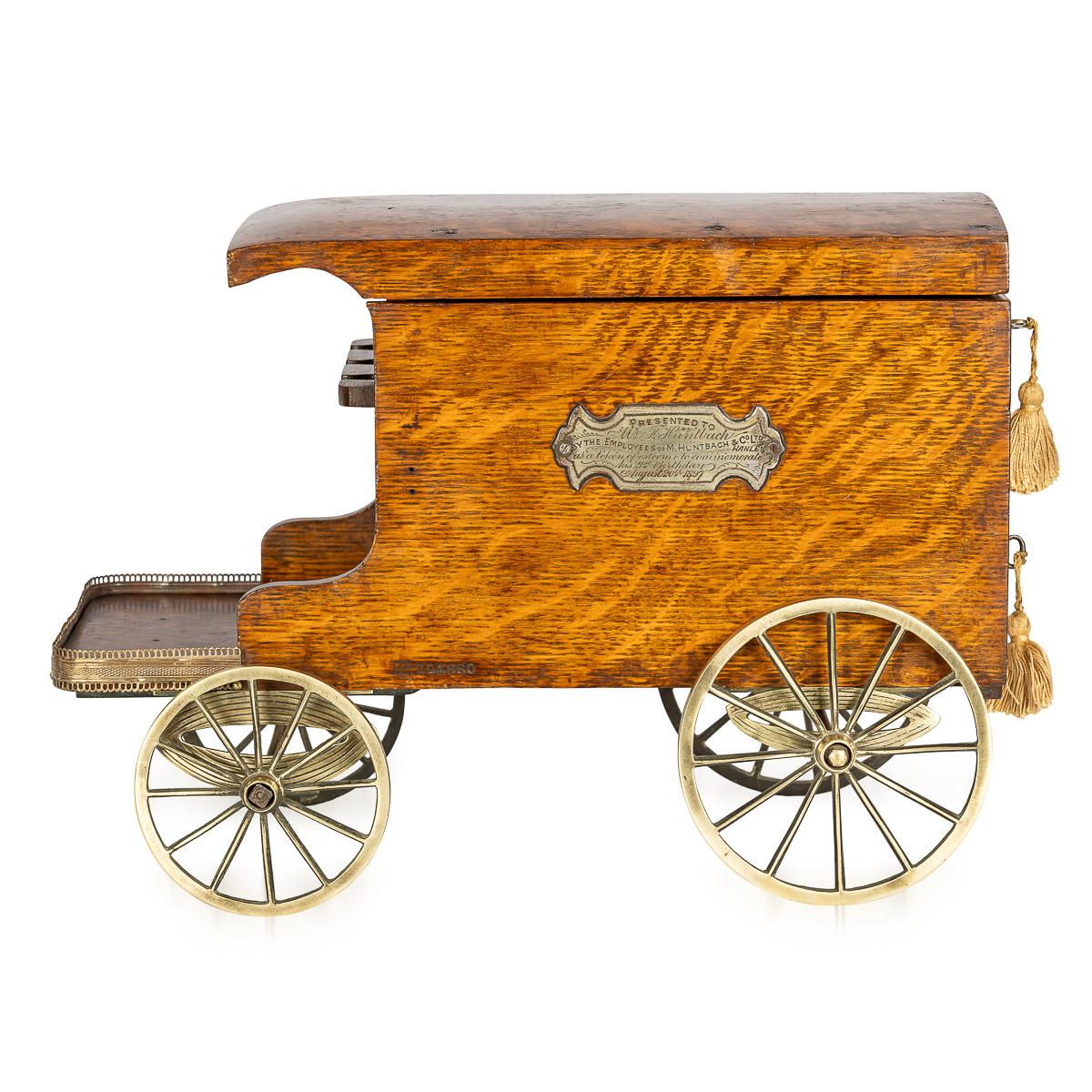Antique late 19th Century Victorian oak smoker's companion ingeniously fashioned in the style of a horse-drawn delivery van. This splendid piece features a hinged lid that gracefully conceals two compartments for storing tobacco, showcasing a