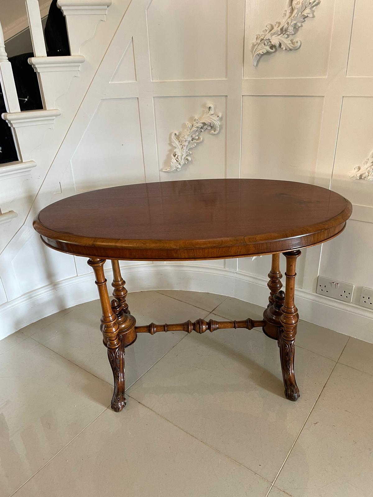 Antique 19th century Victorian oval walnut centre table having a splendid oval solid walnut top and an oval walnut frieze supported by four elegant turned and shaped columns with two turned shaped finials. It is raised on four shaped carved cabriole