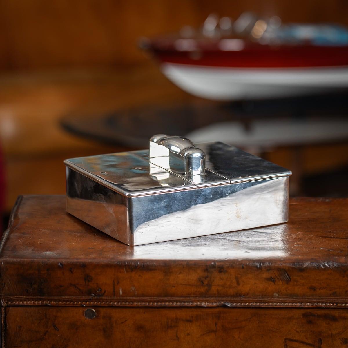 Antique 19th Century Victorian solid silver cigar box. Elegantly crafted, this box features a shaped central handle and two hinged lids that open to reveal a divided compartment and a larger space for cigars. The interior is lined with cedar wood,