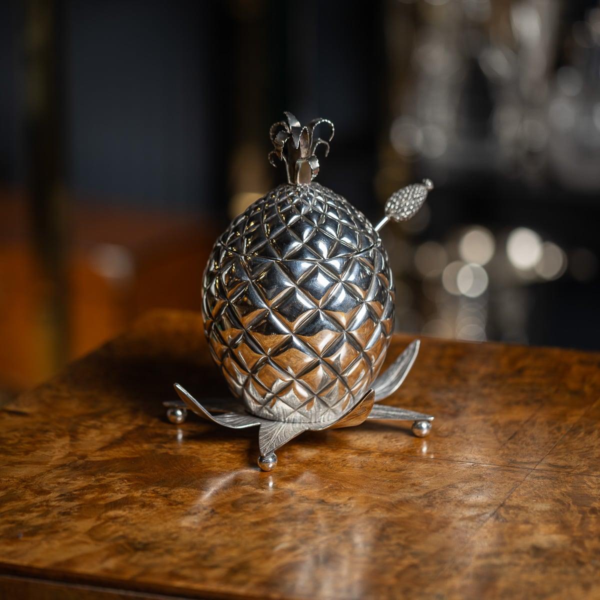 Antique 19th Century Victorian novelty sugar bowl with cover modelled as a pineapple, on a foliate base with ball feet and with a matching sifting spoon with pineapple terminal. Hallmarked English Silver (925 Standard), London, year 1877 (q),