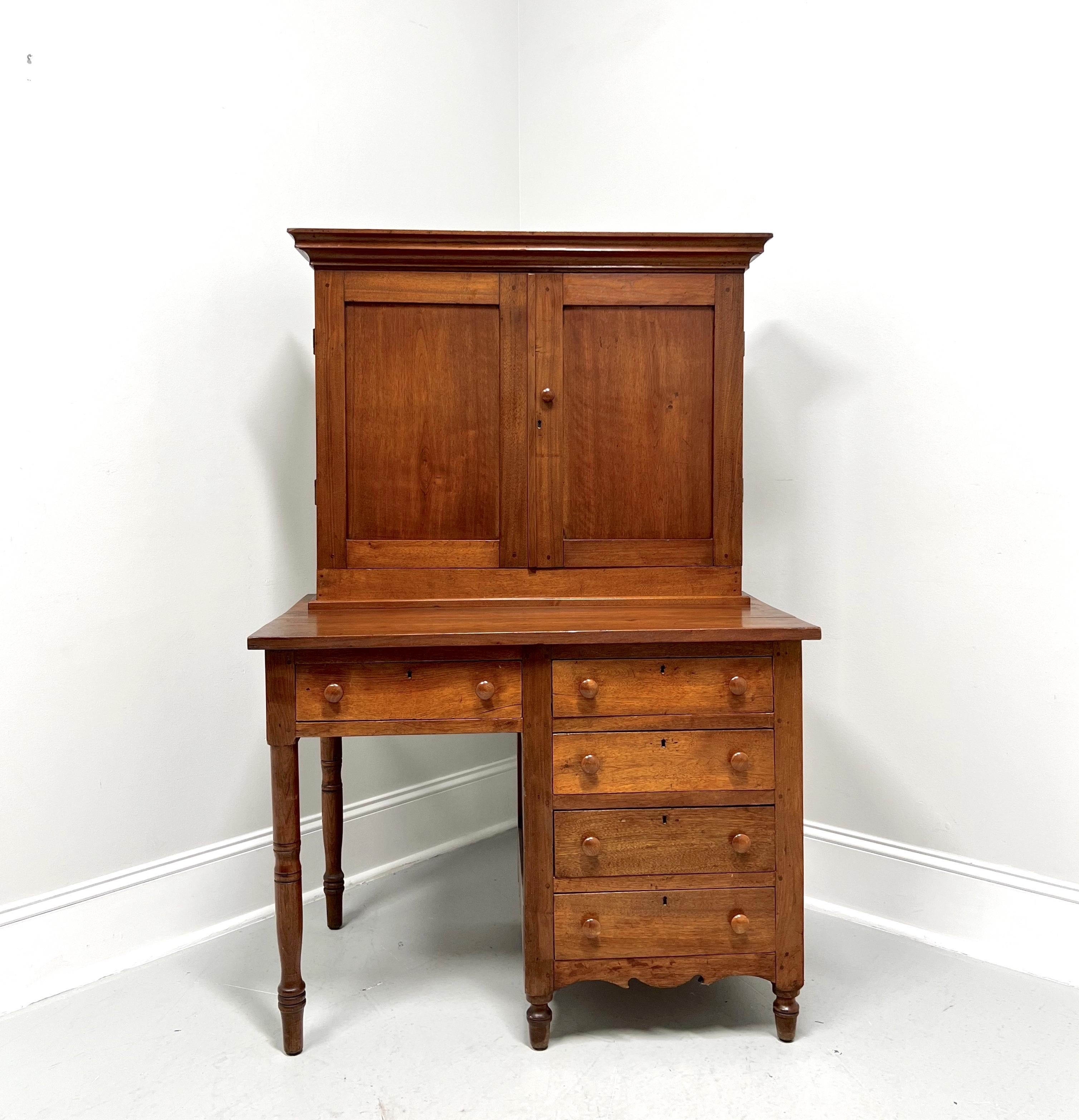 An antique 19th Century American plantation / postal desk, handcrafted by Moravian craftsmen in the Shenandoah Valley of Virginia, USA. Solid walnut, crown moulding to upper cabinet, framed holder for upper cabinet on desk surface, square edge to