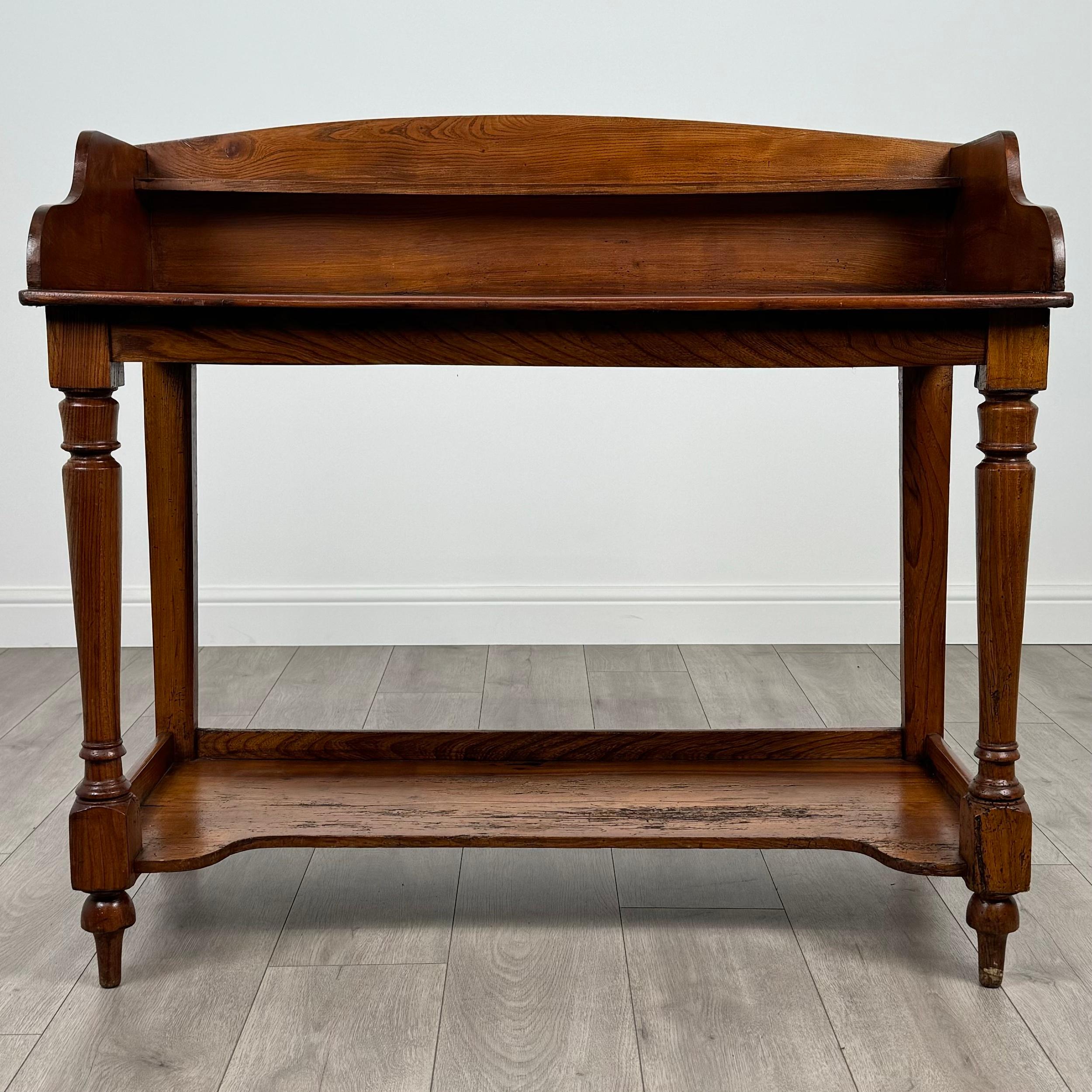 Dieser elegante, aus massiver Eiche gefertigte Waschtisch aus dem 19. Jahrhundert ist ein zeitloses Stück, das klassischen Charme versprüht. 
Er steht auf stabilen, gedrechselten Beinen, die ihm sowohl Stil als auch Stabilität verleihen. Der obere