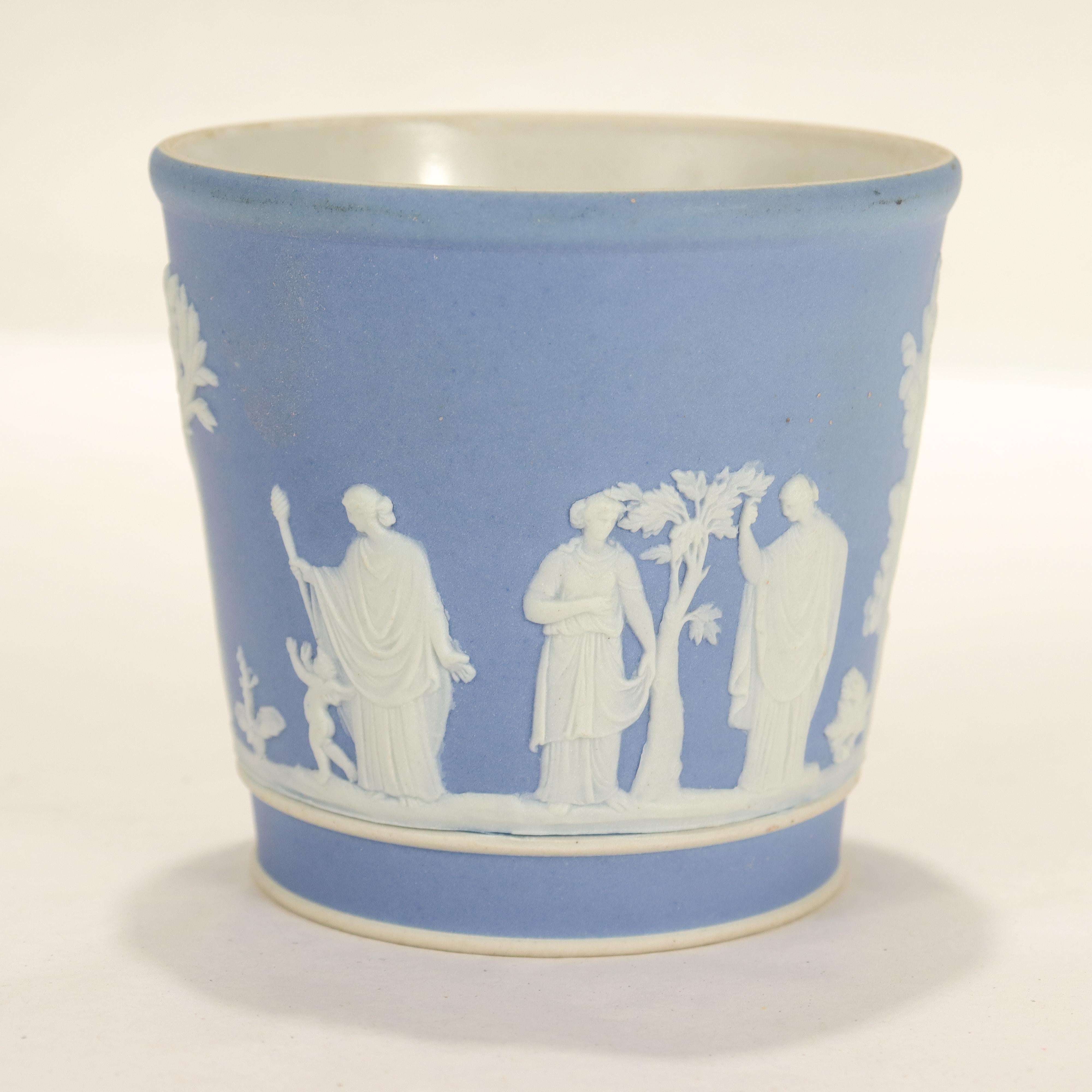 A fine antique Jasperware beaker or cup.

In Wedgwood blue with white relief decoration depicting men, women, children, and trees in a Classical style.

We assume this was used as a tumbler or drinking vessel.

Simply a wonderful Jasperware