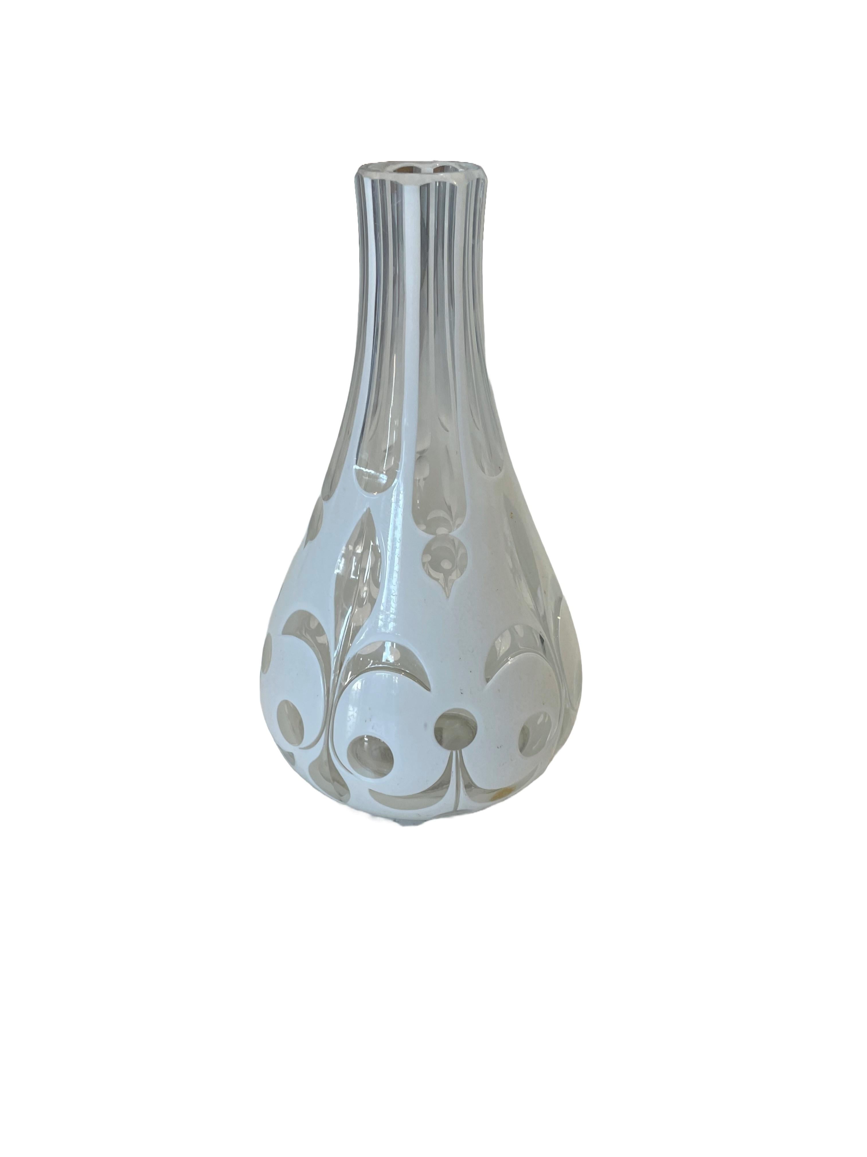 Made by the Bohemian Art Glass manufacturers of the 19th Century, transparent glass with white opaline glass overlay is hand-cut in whimsical a fleur de Lis-themed pattern. This decorative piece is ideal as a vase.