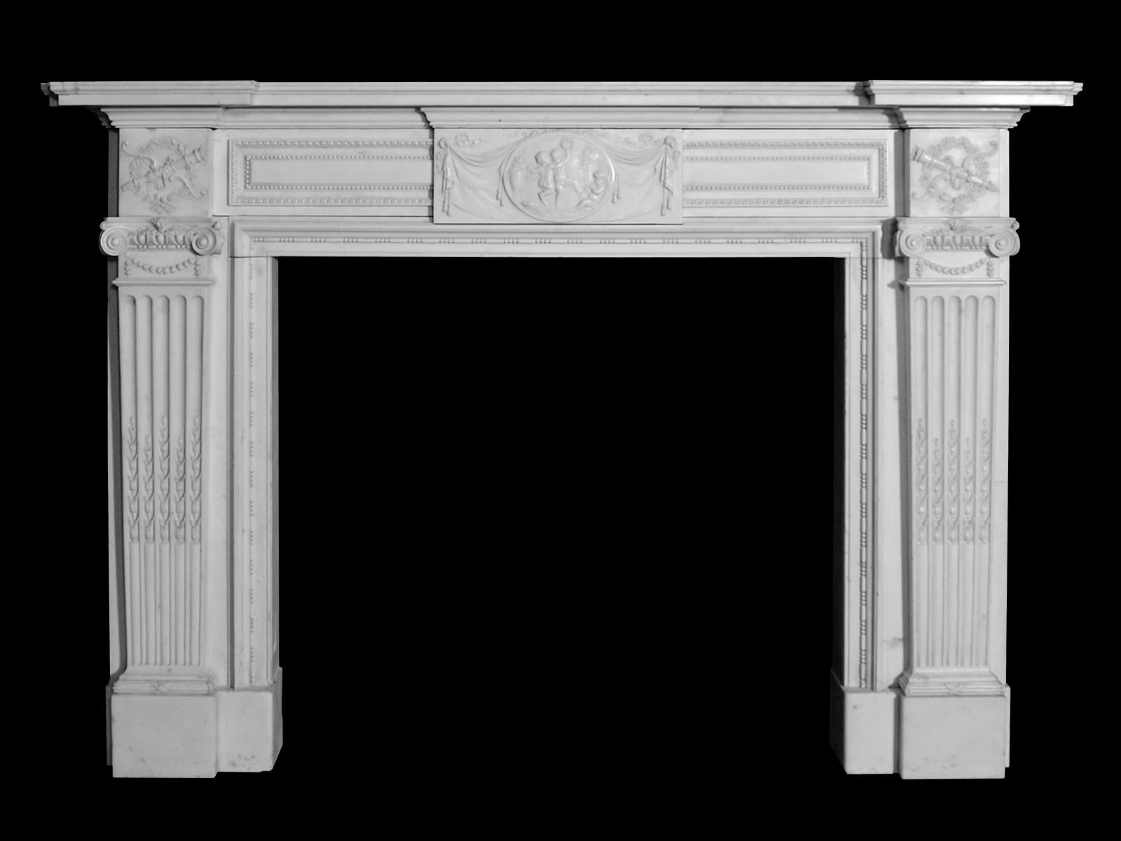 A 19th century Regency style fireplace, executed in Italian statuary white marble, having fluted pilaster jambs inset with bell husks terminating beneath ionic capitals. The end blockings of finely carved garland, quiver and arrows. The centre