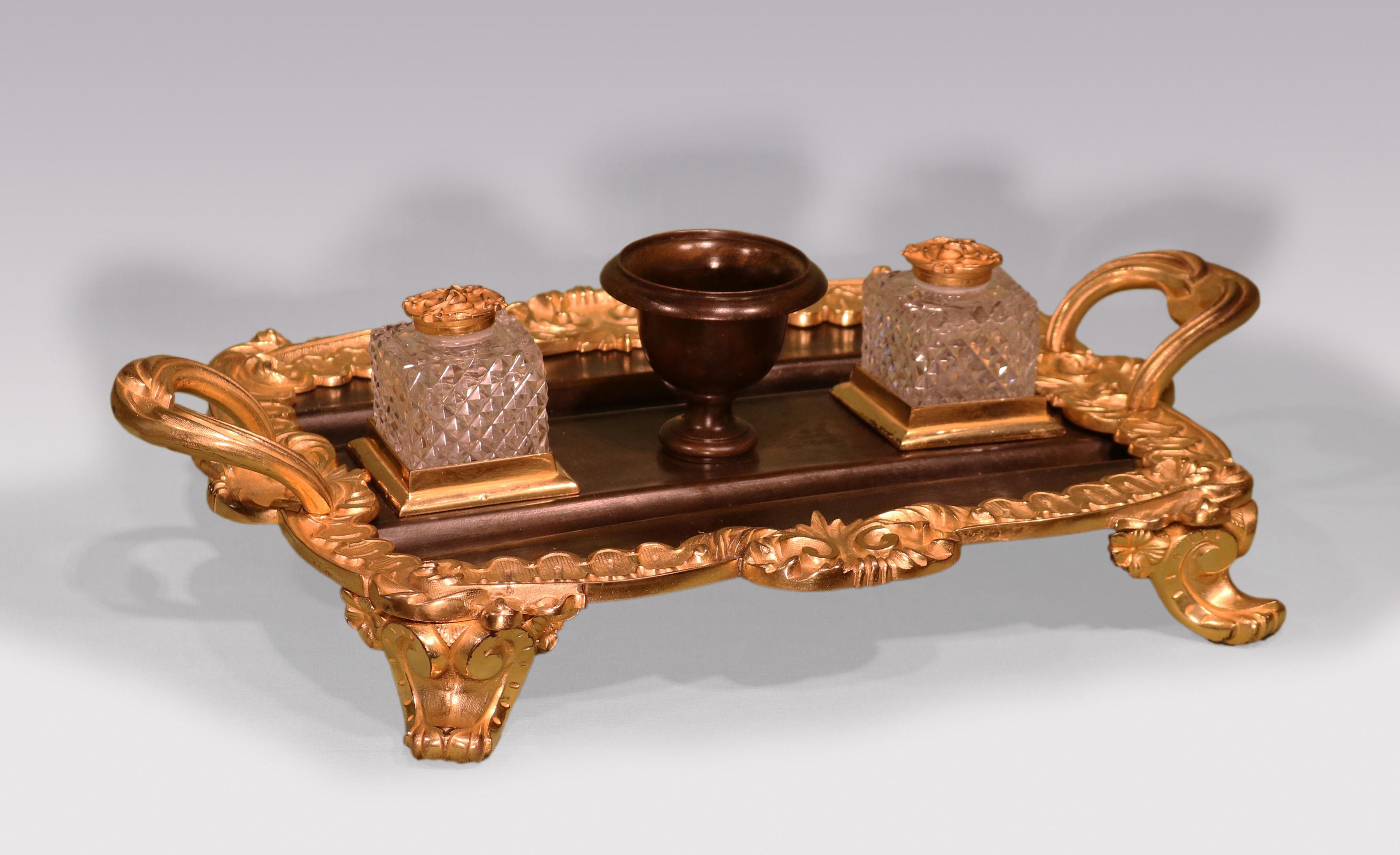 Un grand Pentray en bronze et bronze doré d'époque William IV avec des encriers en verre taillé et une urne centrale avec une bordure de feuilles et de coquillages et des poignées de transport, supporté par des pieds en forme de feuilles et de