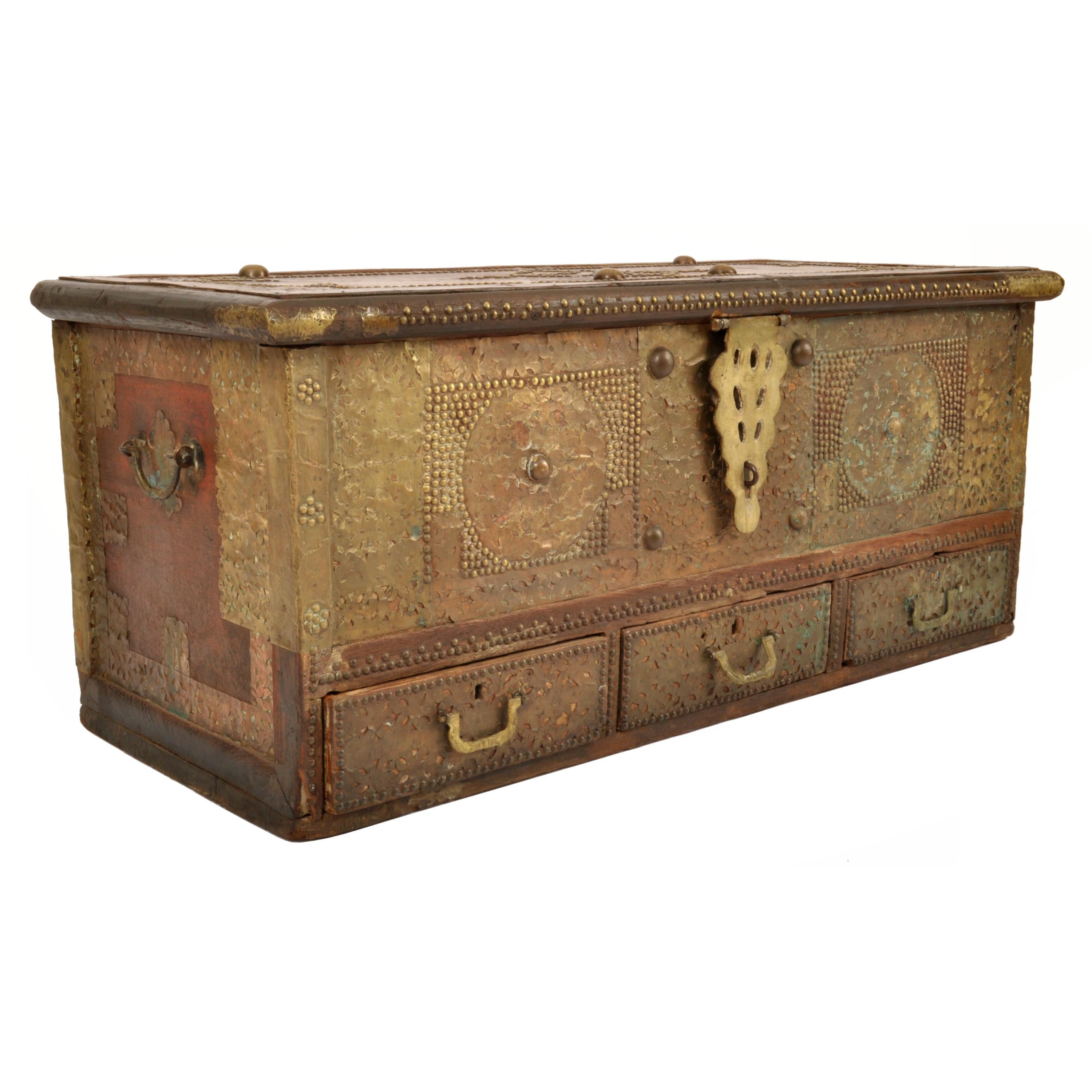 A good antique 'Zanzibar' teak and brass stud work with copper overlay dowry chest, circa 1850.
A better than the usual Zanzibar dowry chest, the hinge lidded chest profusely decorated with brass studwork in geometric designs, also clad with