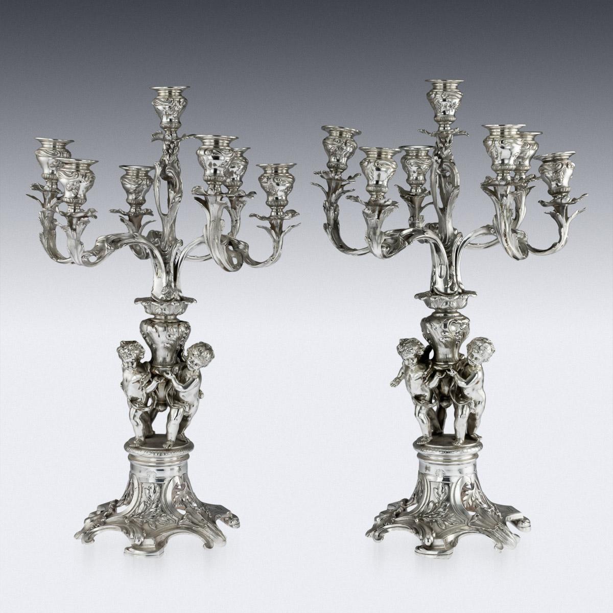 Antique late 19th century Austrian pair of magnificent seven-light candelabra, large and exceptional quality, in the Louis XV style, the foot pierced with oak foliage, the stem shaped as three putti, supporting seven laurel leaf branches, the tops