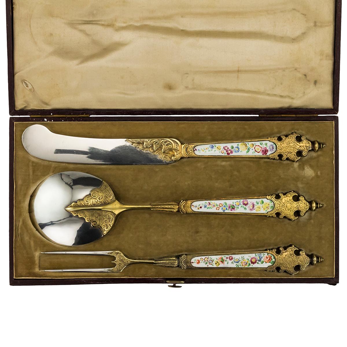 Antique mid-19th century German solid silver traveling cutlery set, made in the style of the early 17th century Augsburg examples, the set comprising a fork, a knife and a spoon, each richly gilt and beautifully engraved, handles mounted with enamel