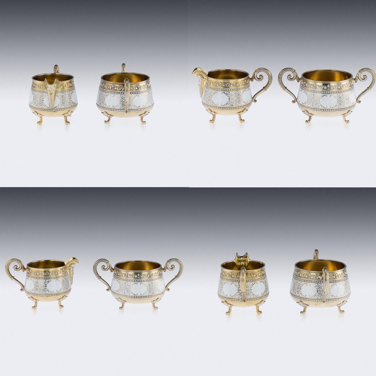 Antique 19th century Norwegian silver-gilt & cloisonneé-enamel tea service, comprised of a sugar bowl, cream jug, 12 cups, 12 saucers and 12 spoons, decorated with white enamel on floral scrolls, with white intertwining and beaded boarders on