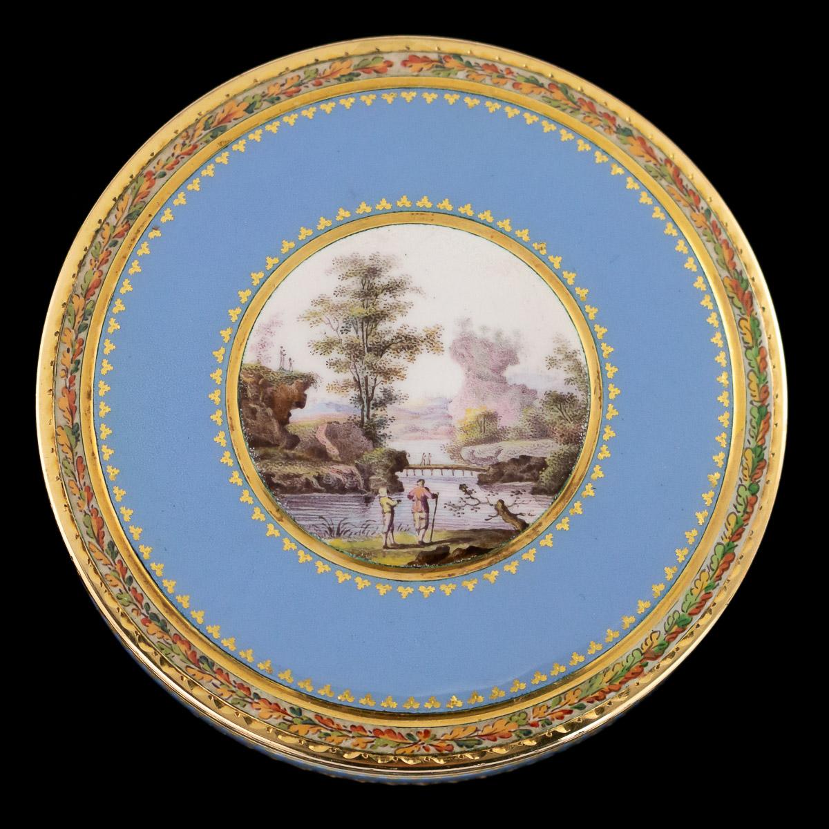 Antique early 19th century Swiss 18-karat gold bonbonniere box, the lid set with a round enamel panel painted on white ground depicting two gentleman looking at a countryside landscape, within a fine gilt leaf frame, surrounded by translucent blue
