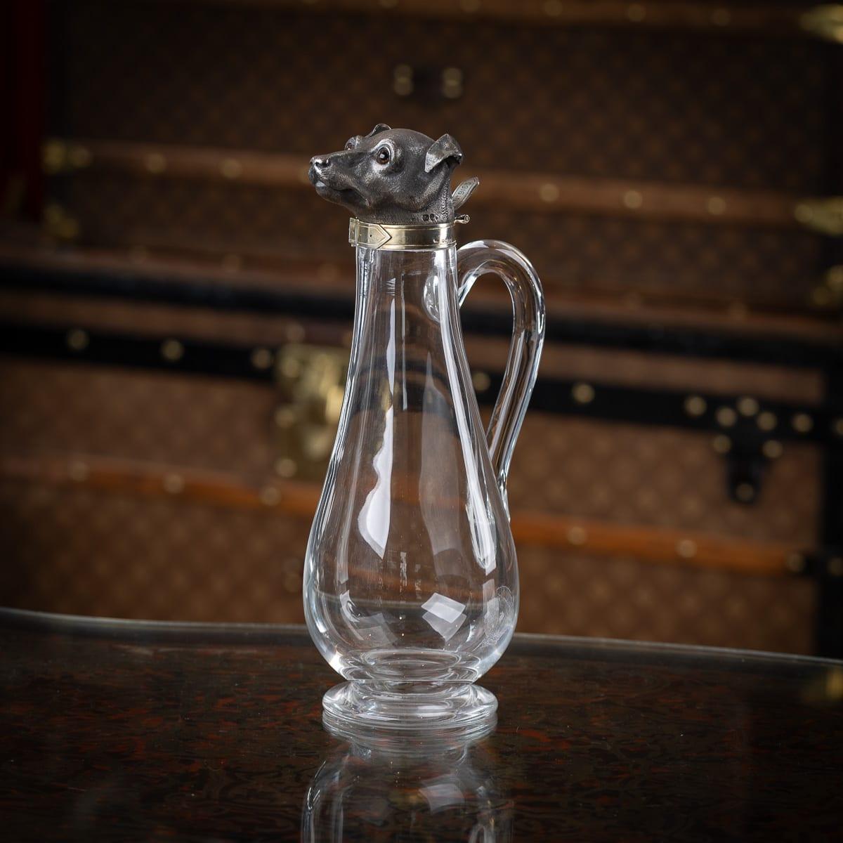 Antique 19th Century Victorian solid silver and blown glass claret jug, designed with a whippet head as the hinged lid. The head features glass eyes and a gilt silver rim shaped into a buckled collar. A glass handle is mounted on the side of the