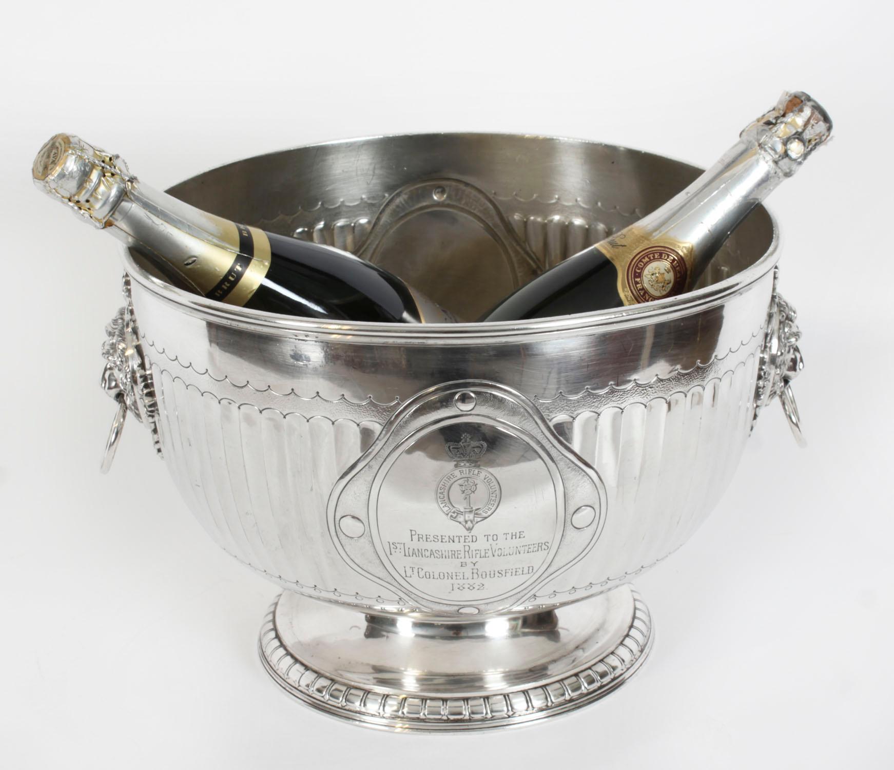 This is an exceptional antique English Neo-classical Revival silver plated wine cooler bearing the makers mark of the renowned English silversmith Elkington, dated 1873.
 
The wine cooler is raised on a circular pedestal base with a reeded body and