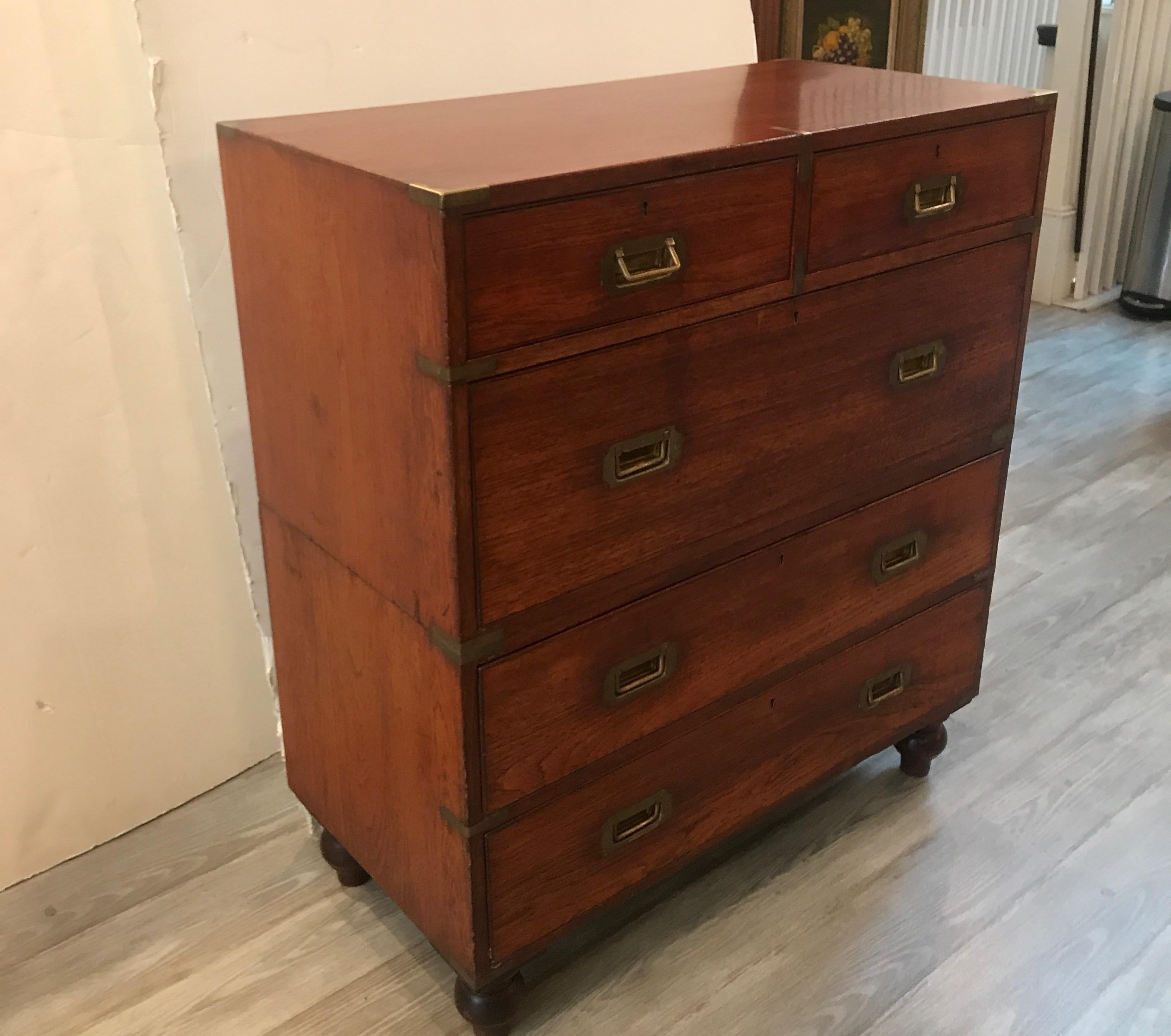 A 2 part mahogany campaign chest with brass handles and hardware. The top piece with 2 smaller drawers over on larger drawer the bottom with 2 larger drawers. Dovetailed constructed case on original turned feet. The side with two old veneer repairs