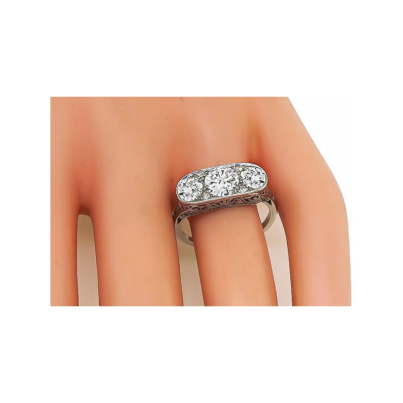 This is an elegant platinum ring from the Edwardian era. The ring is centered with a sparkling old European cut diamond that weighs approximately 1.00ct. The color of the diamond is G with VS2 clarity. The center diamond is accentuated by two
