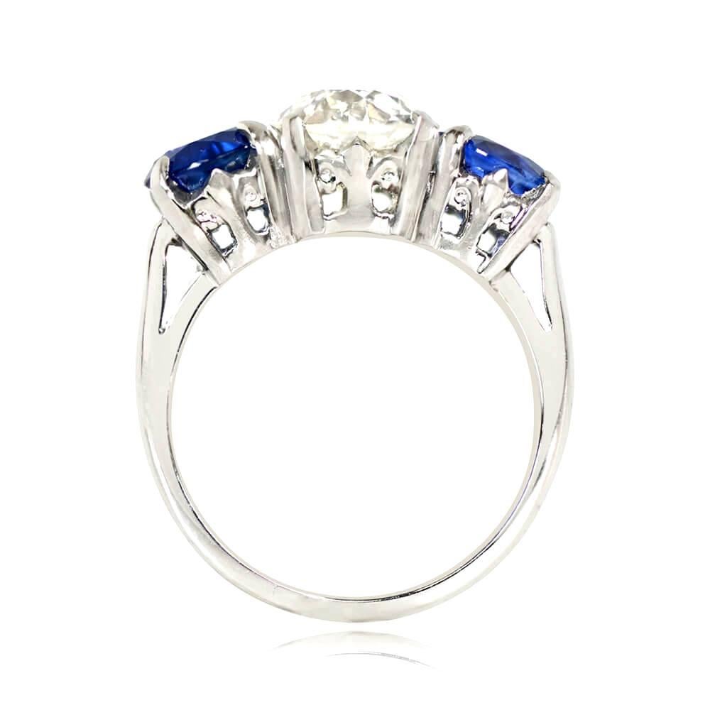 This antique Art Deco three-stone engagement ring boasts a 2.04-carat old European cut diamond, J color and VS1 clarity, prong-set and complemented by two round cut sapphires weighing 2.56 carats in total, also held in prongs. Crafted in platinum,