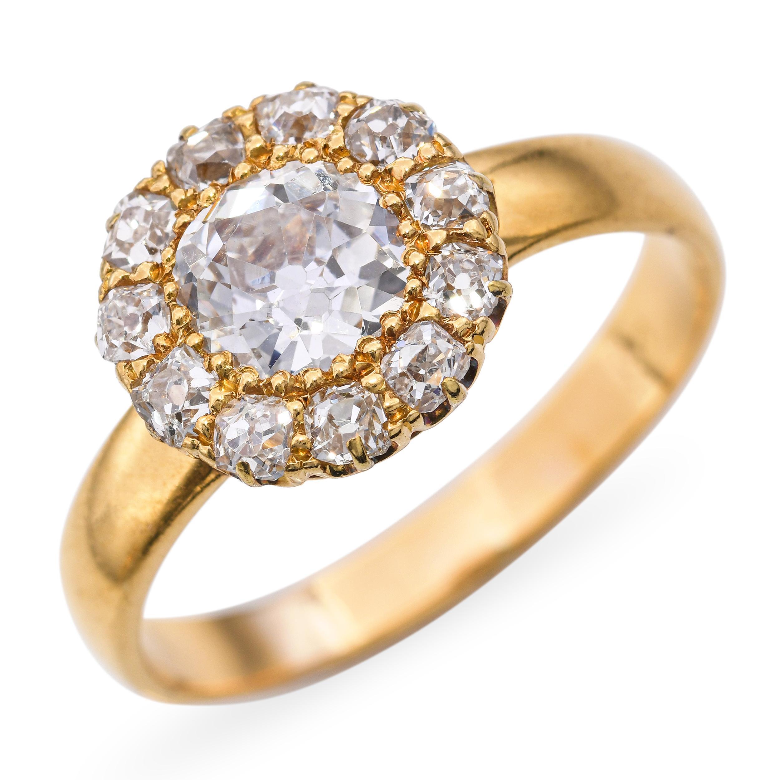 Dieser exquisite antike Verlobungsring ist aus 20 Karat Gelbgold gefertigt und zeigt einen atemberaubenden Diamanten mit altem europäischem Schliff, umgeben von alten Minenschliffen. Der Mittelstein ist von einem zarten Halo kleinerer Diamanten