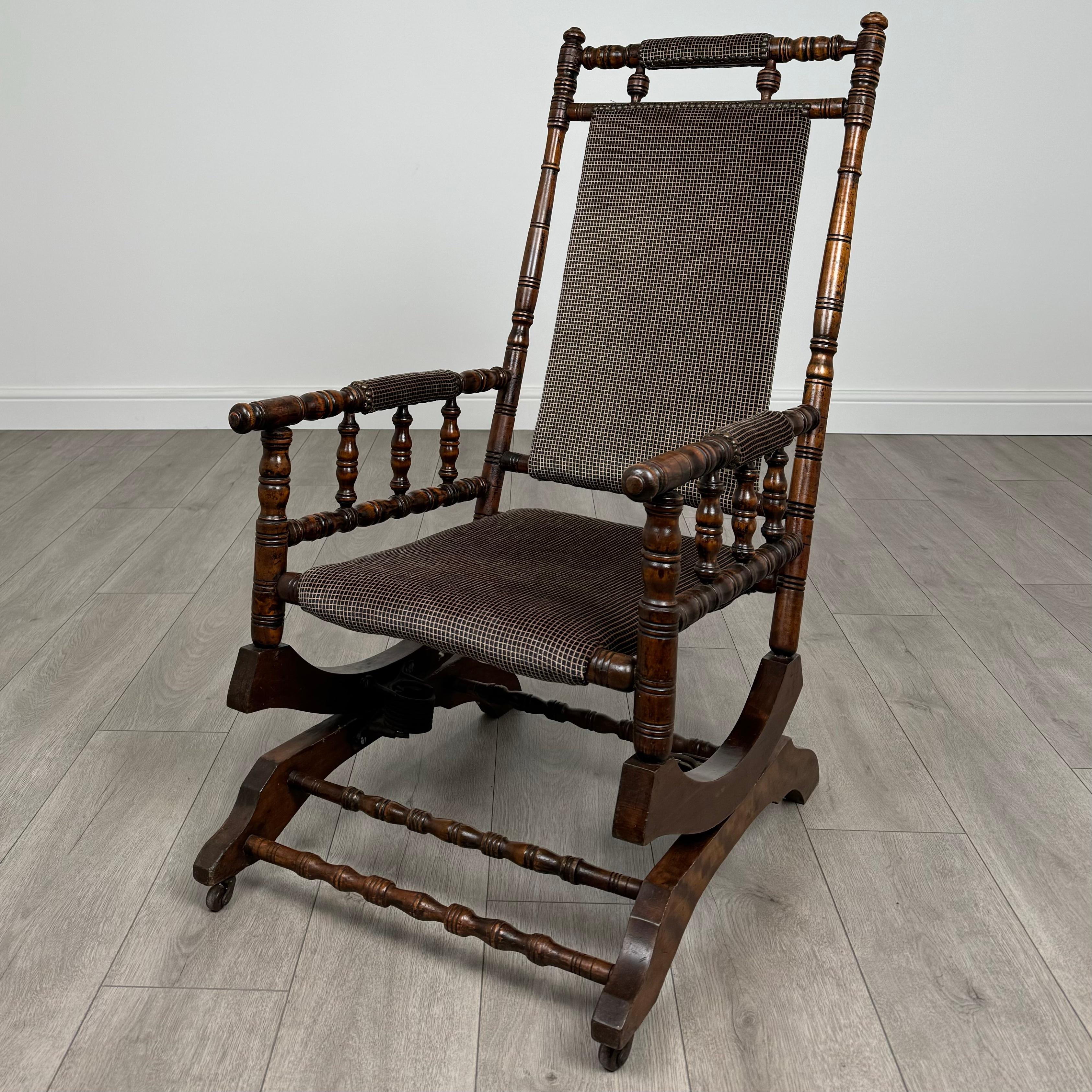 Ce charmant rocking-chair américain du XXe siècle est fabriqué en hêtre et offre à la fois confort et style. La chaise est dotée d'un cadre magnifiquement tourné, qui met en valeur le savoir-faire et la qualité de sa construction. 
Le revêtement est
