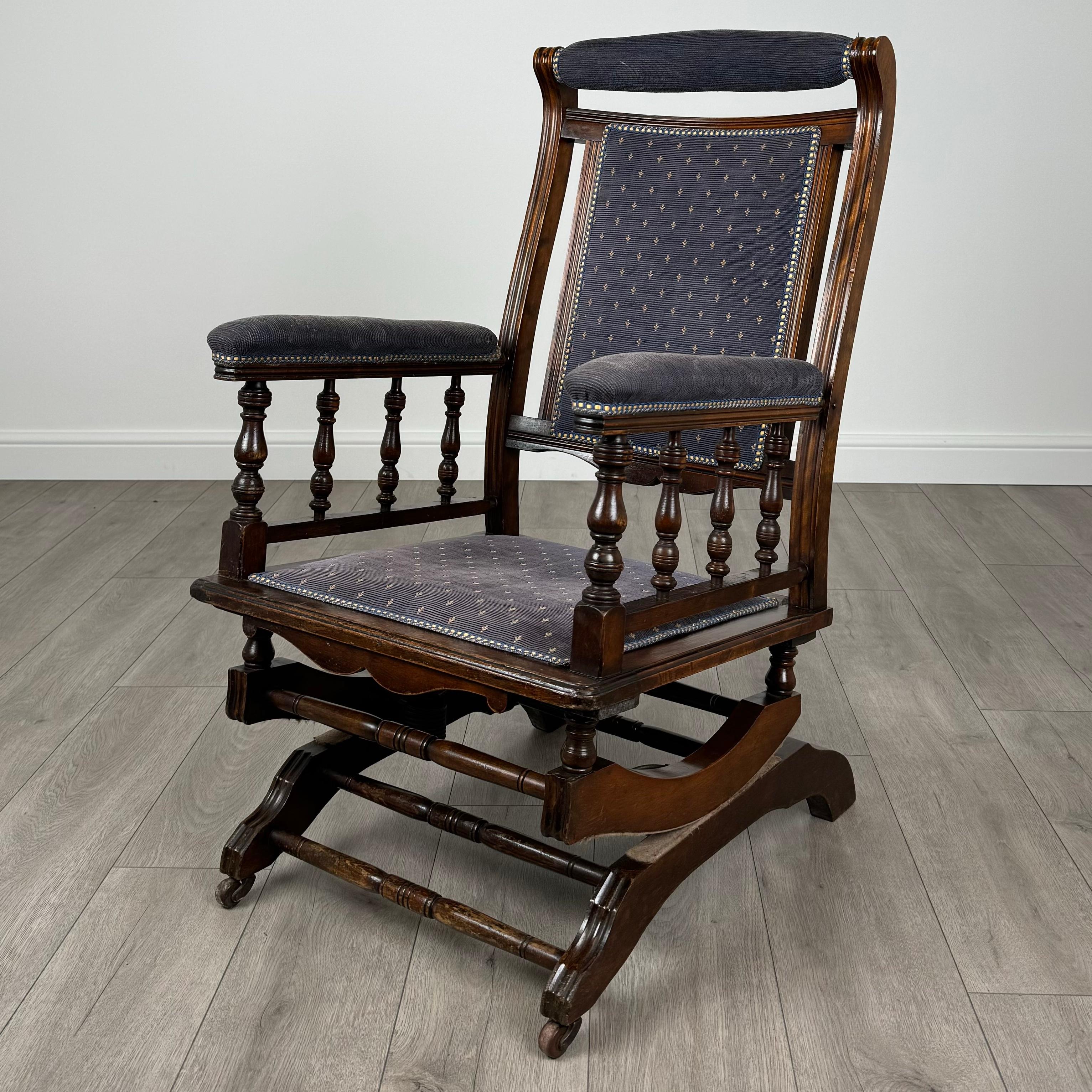 Ce rocking-chair américain antique du XXe siècle est fabriqué en bois de hêtre, offrant à la fois durabilité et charme. 
Monté sur roulettes pour une mobilité aisée, ce rocking-chair est doté d'un dossier, d'une assise et d'accoudoirs joliment