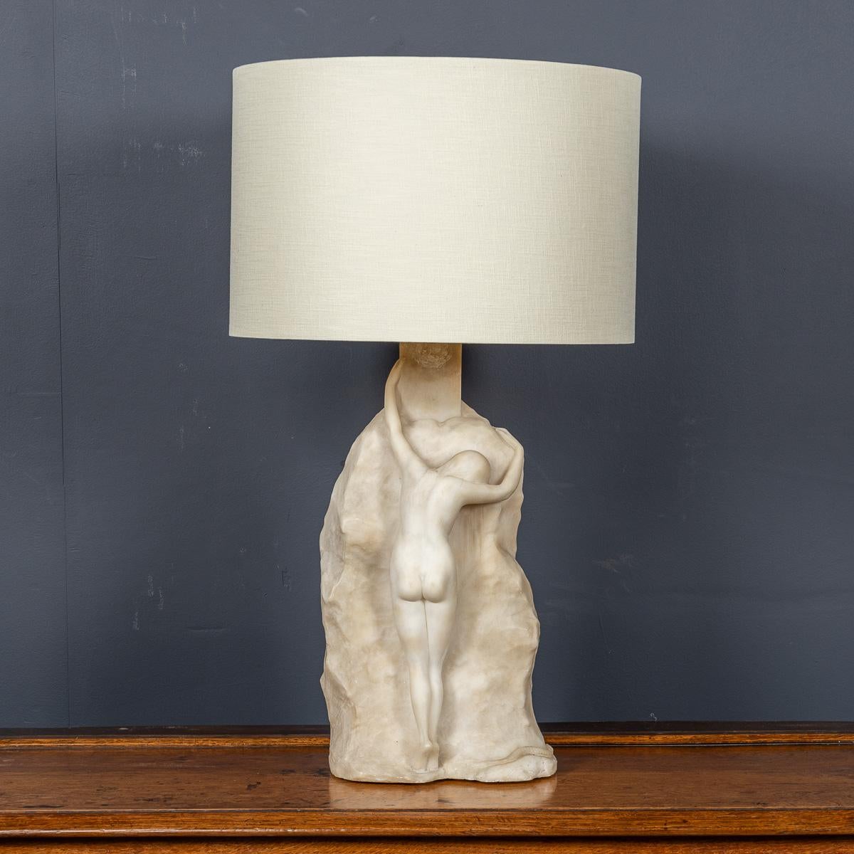 Antike Marmorlampe des 20. Jahrhunderts. Der Sockel dieser Art-Déco-Lampe zeigt die anmutige Figur einer jungen Frau, die sich über einen Felsen lehnt. Sie ist fein aus weißem Marmor gemeißelt. Der zeitgenössische Schirm ist dezent, so dass die