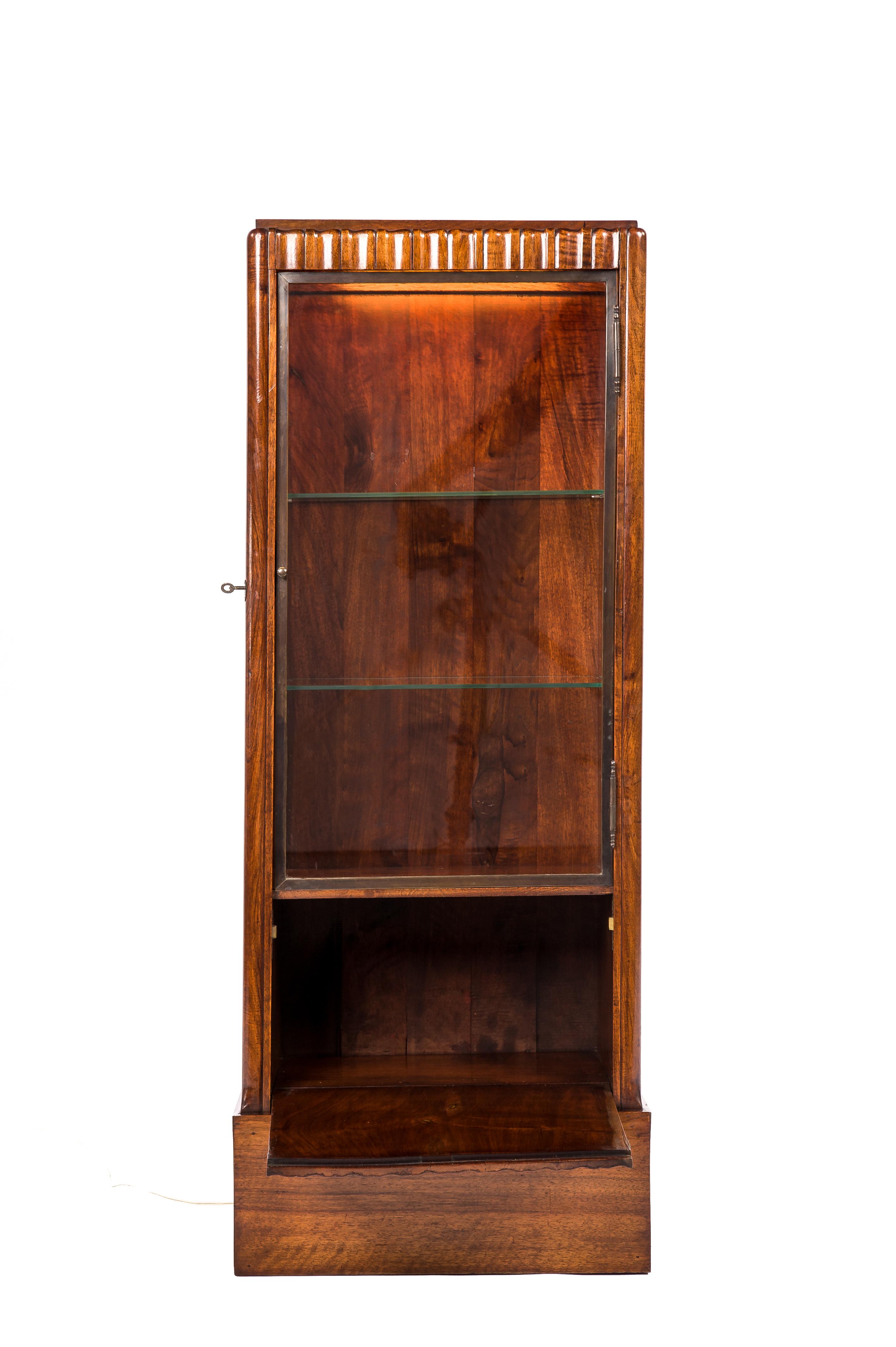 This beautiful proportioned fluted dry bar or liquor cabinet was made in the Netherlands circa 1920. It is a freestanding piece that is elegantly fluted with convex-concave teak slats throughout. On the front, the cabinet has a clean glazed door