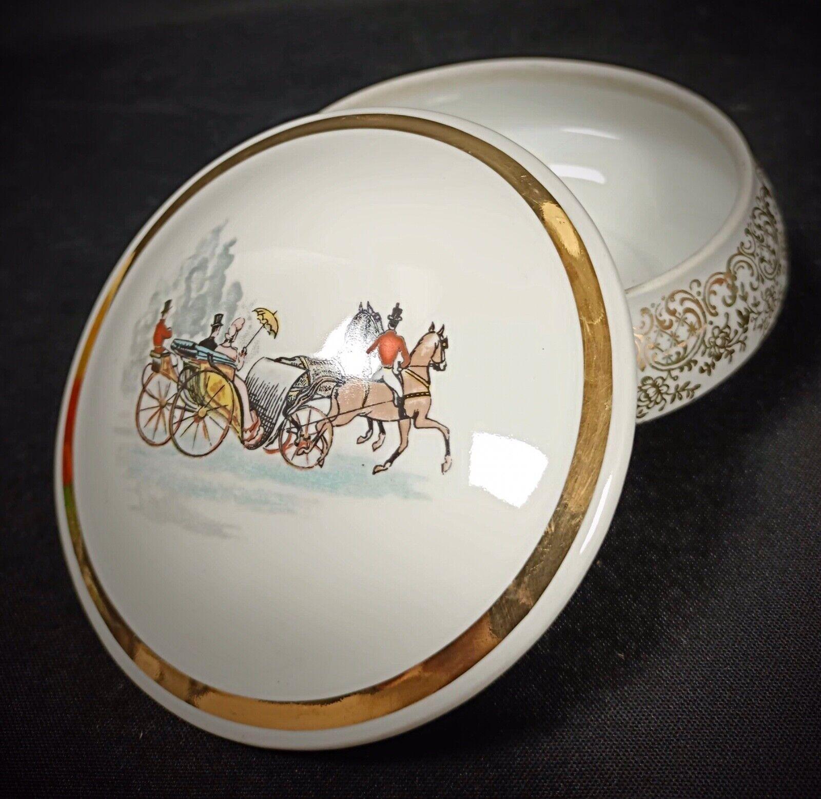 Rehaussez votre collection avec cette exquise bonbonnière ancienne, fabriquée en porcelaine I.L.A. authentique et représentant une charmante scène de carrosse. Cette pièce délicate témoigne de l'élégance et de l'attention portée aux détails,