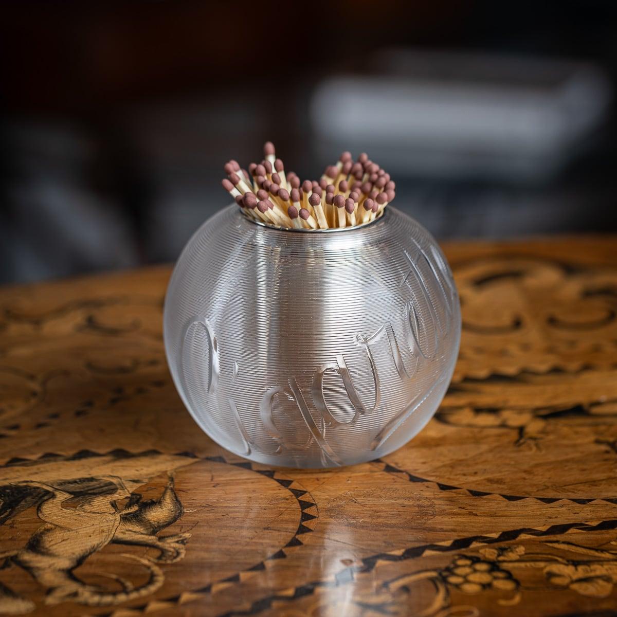 Antique 20th Century British silver plated mounted match striker featuring textured, ribbed glass. The round glass body is engraved with the word 