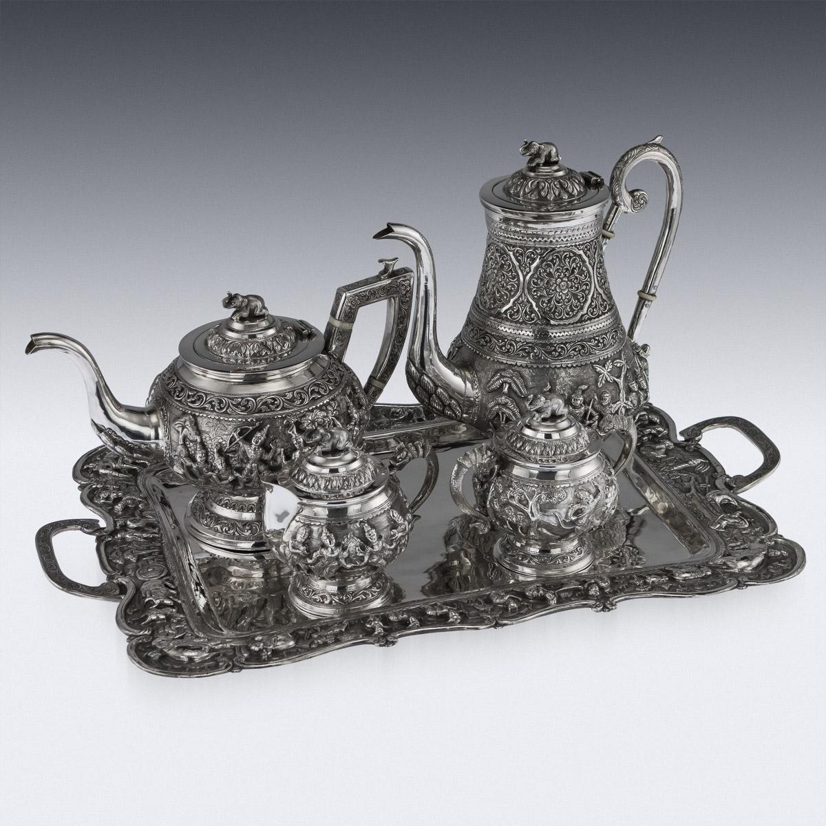 Antique early-20th century Burmese colonial solid silver four piece tea and coffee set on a tray, comprising of teapot, coffee pot, lidded sugar bowl, and lidded cream jug and a tray, each piece is highly-decorative, chased and repoussed with