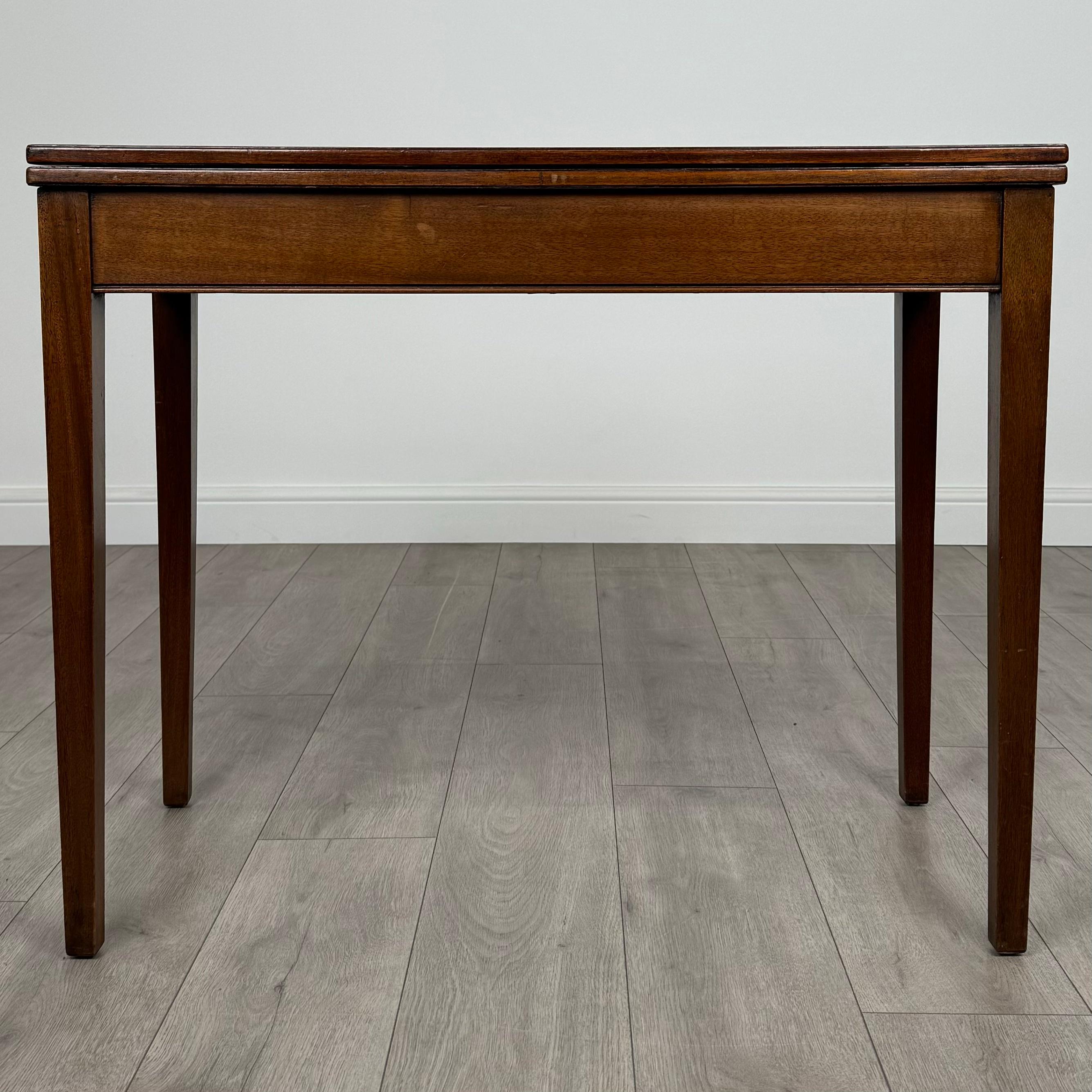 Cette table à cartes ancienne du XXe siècle, fabriquée en acajou riche, est une pièce magnifiquement conçue et de grande qualité. Posé sur de solides pieds carrés, il présente une esthétique raffinée et élégante, avec un magnifique grain et des