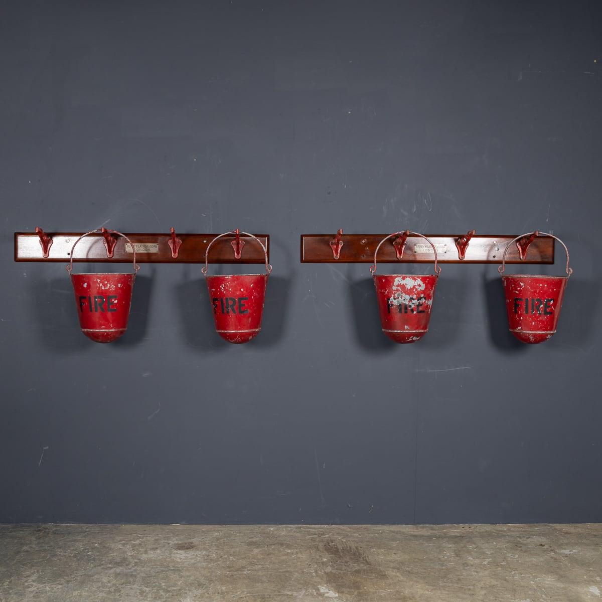 Antique early 20th Century Edwardian cast iron hooks by Merryweather & Sons of London, accompanied by four round-bottomed metal fire buckets. The set includes a pair of cast iron hooks mounted to a wooden plinths (totalling 8 hooks, 2 separate
