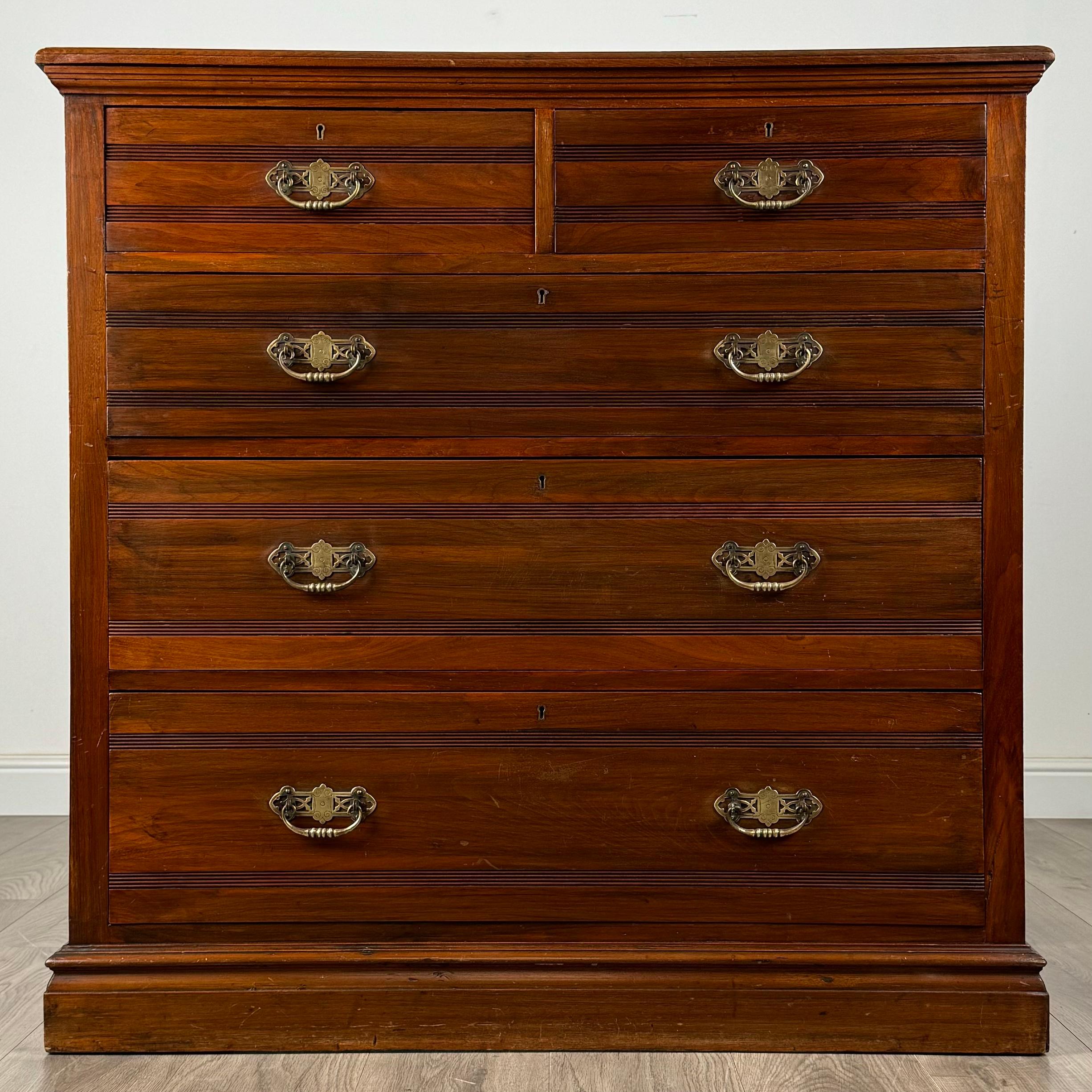 Questa splendida cassettiera del XX secolo, realizzata in noce, emana un'eleganza senza tempo grazie al suo design classico e all'estetica calda e invitante. La cassapanca poggia su una robusta base a zoccolo, fornendo una solida base che completa