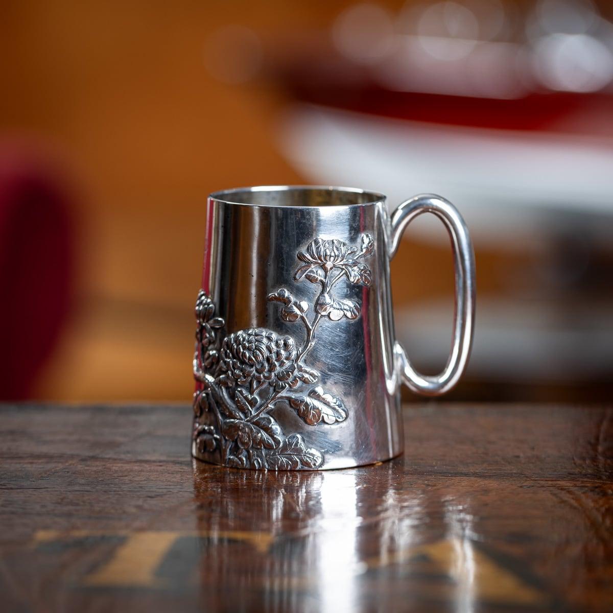 Antiker Becher aus massivem, chinesischem Exportsilber des frühen 20. Jahrhunderts, spitz zulaufende Form, mit c-förmigem Henkel, appliziert mit Kirschblüten und Chrysanthemen, graviert mit Initialen. Gepunztes chinesisches Exportsilber 90 (900er