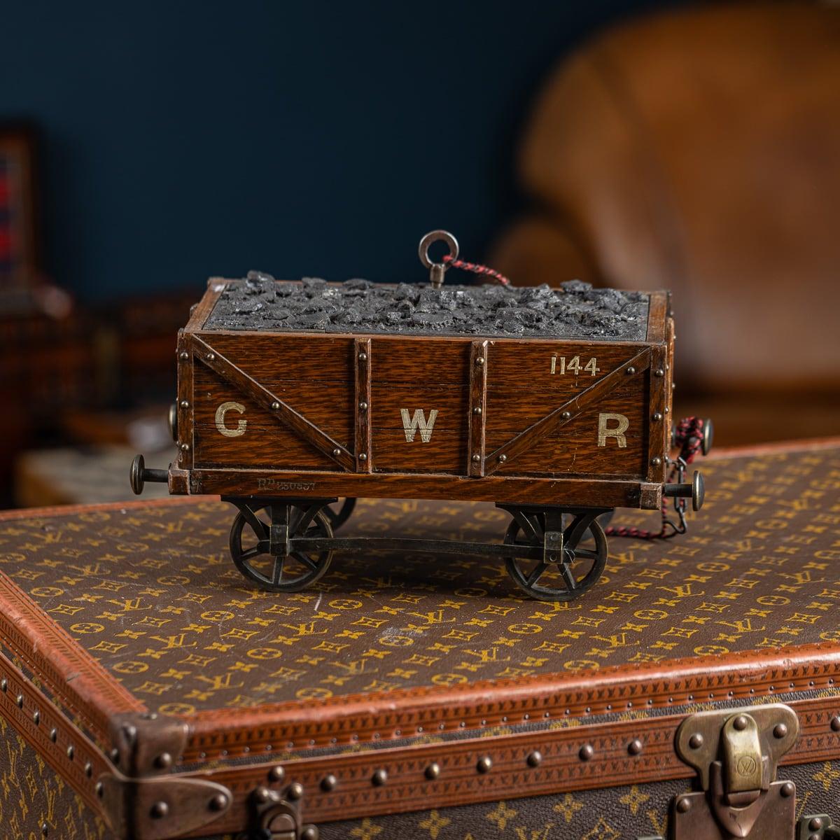 Ancienne boîte de rangement en chêne et en métal du début du 20e siècle de l'époque édouardienne, représentant un tender de wagon à charbon pour une locomotive. Le bois et le métal sont magnifiquement patinés et le dessus du wagon présente une