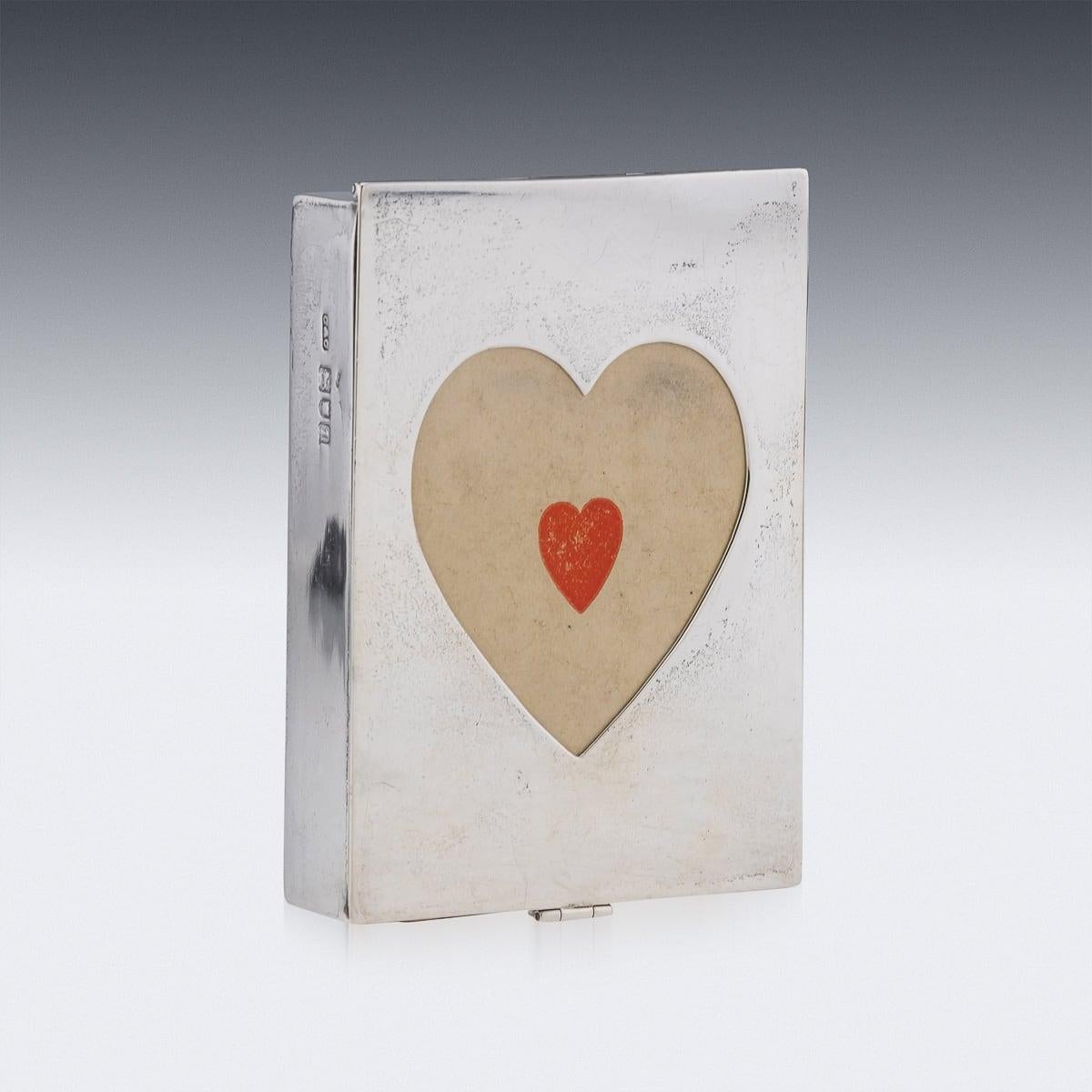 Antique 20th Century Edwardian solid silver playing card box with a sleek, plain exterior. It features two cut-out shapes—a heart and a diamond—allowing a glimpse of the cards inside, even when the box is secured with its small latch. This charming