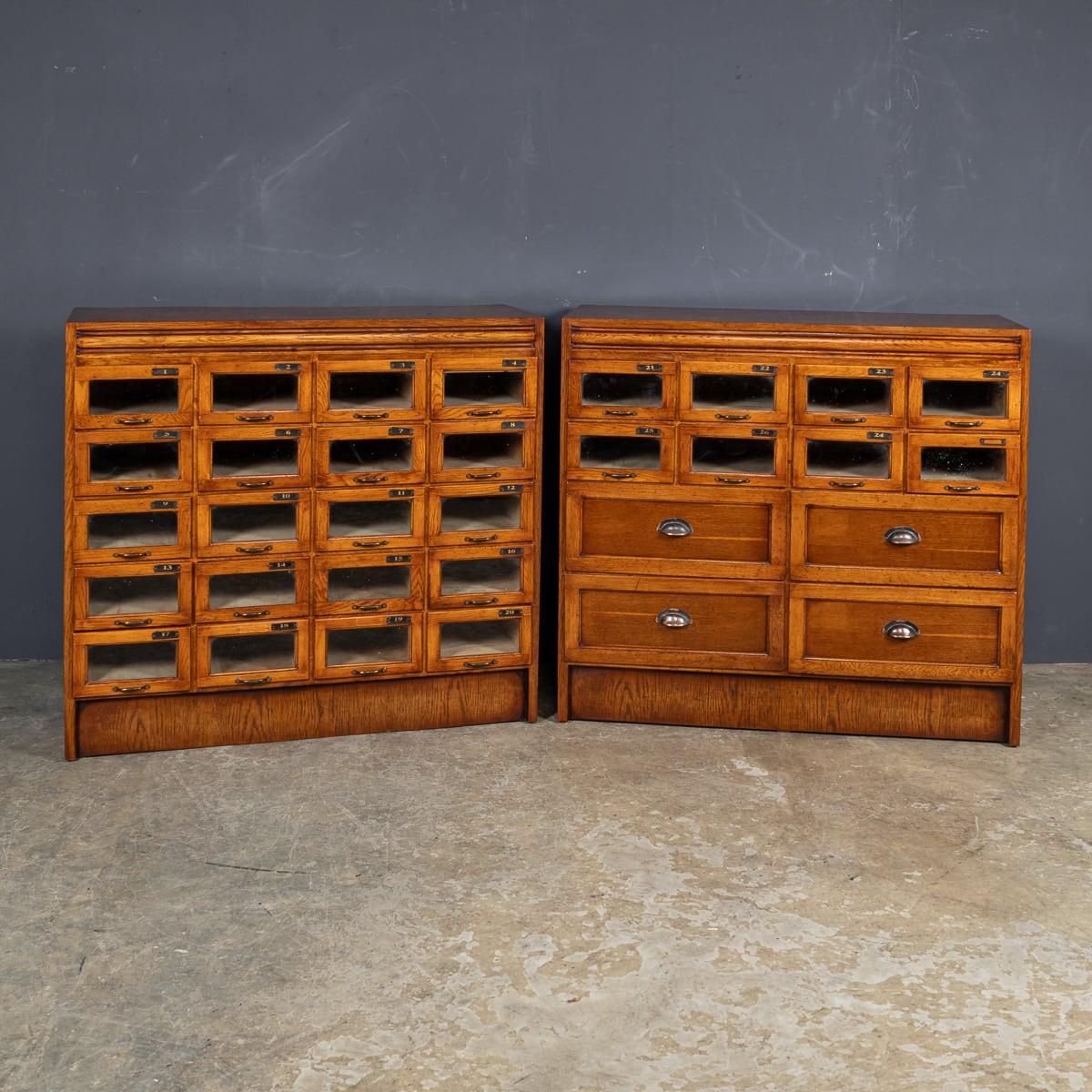 Ancienne paire de tiroirs de mercerie en chêne anglais du début du 20e siècle. L'un des meubles présente une façade entièrement en verre pour ses tiroirs, tandis que l'autre combine des tiroirs plus grands avec des tiroirs à façade en verre. Les