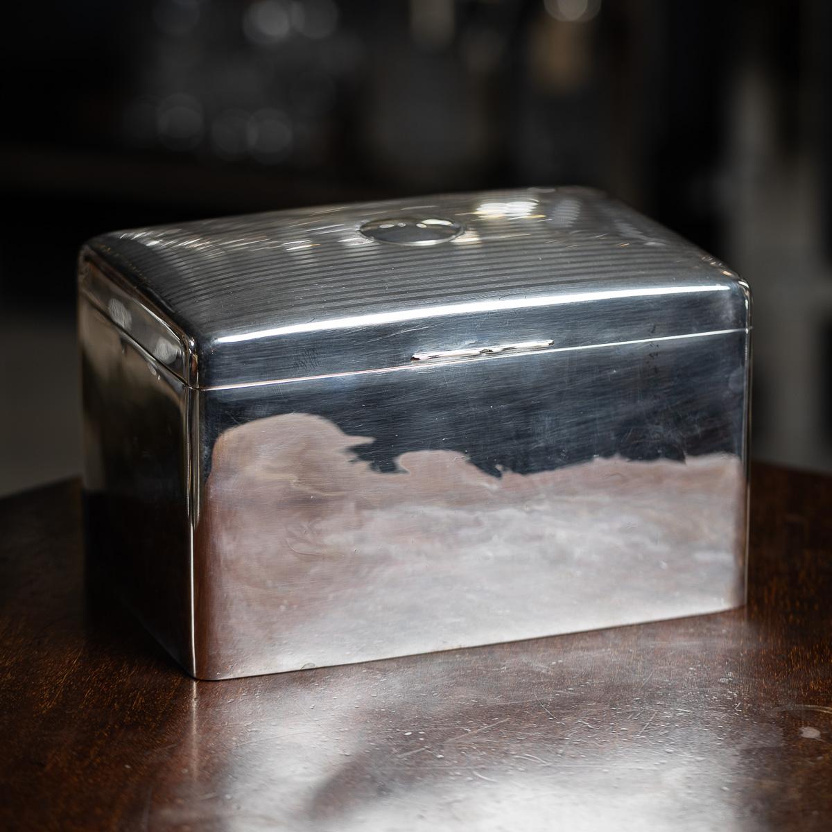 Antico portasigari in argento massiccio inglese del XX secolo. Realizzata con eleganza, questa scatola presenta un motivo a strisce tornite sul coperchio superiore. Il resto della scatola è semplice con angoli arrotondati. Argento inglese con