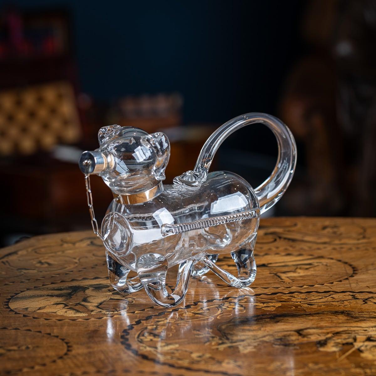 Antigua jarra de clarete inglesa de principios del siglo XX de plata maciza y cristal con forma de perro. La jarra tiene un cuerpo de cristal meticulosamente elaborado, con forma de perro. Un collar de plata de ley está unido por una cadena a un