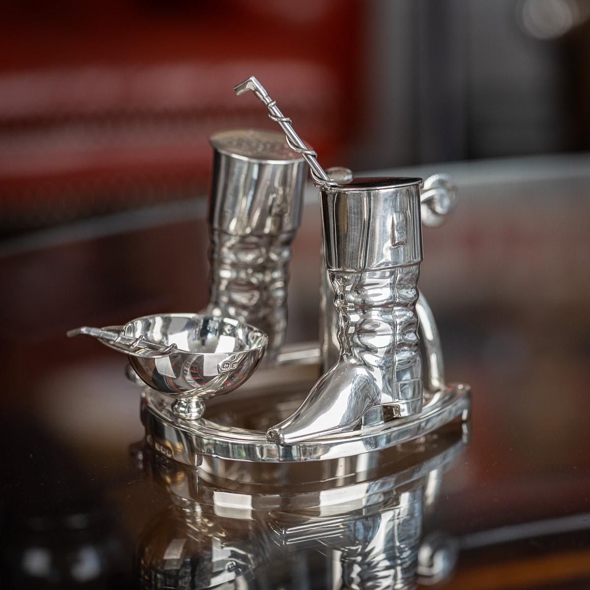 Antiguo y novedoso juego de condimentos de plata maciza eduardiano de principios del siglo XX en forma de herradura. Con un mango en forma de espolón, una tapa de jinete invertida para la sal abierta, botas desmontables como pimentero y recipiente