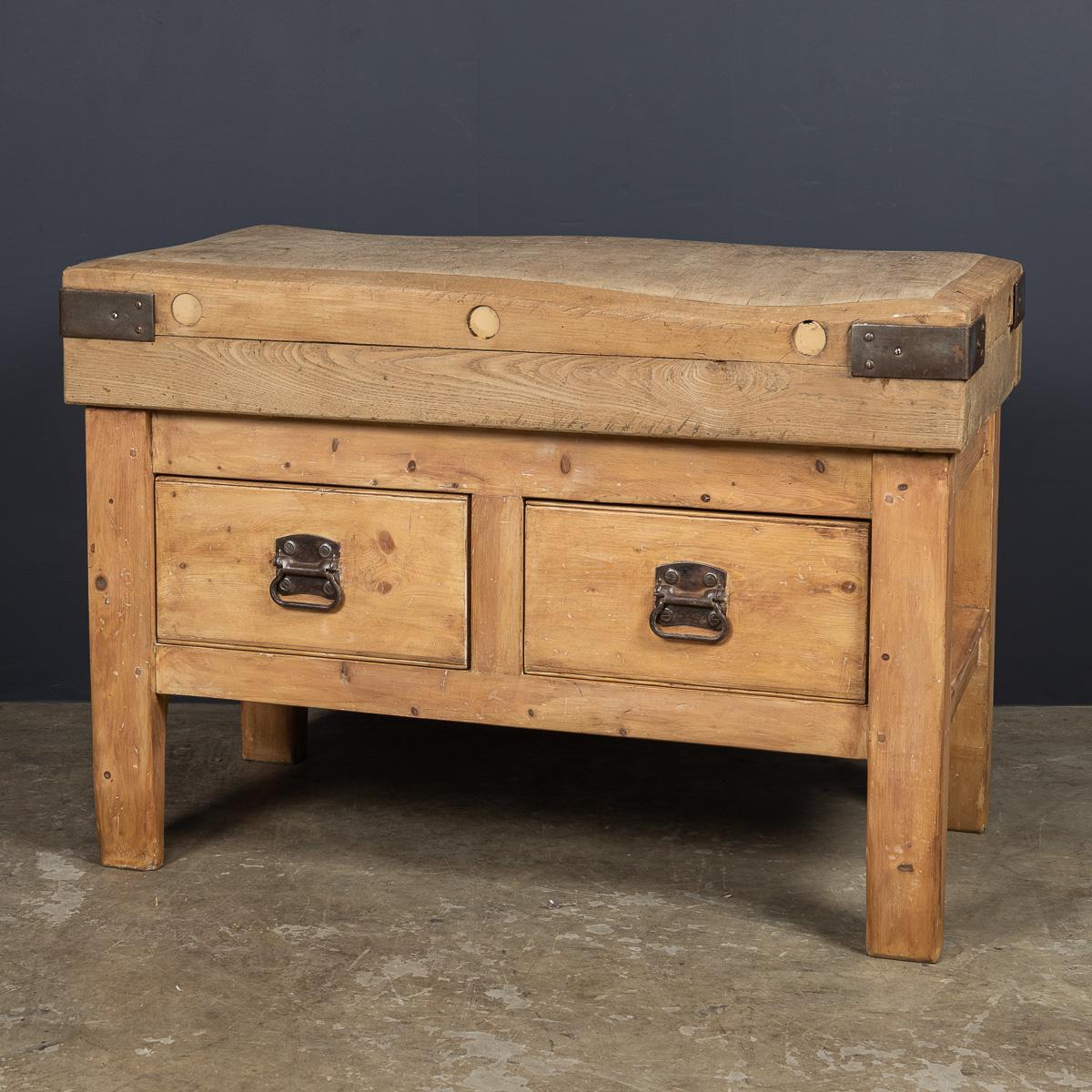 Ancien billot de boucherie français du 20e siècle en bois massif robuste, renforcé par des courroies en fer. Il comporte deux tiroirs à double aspect, chacun doté d'élégantes poignées Art déco en métal de part et d'autre. Une addition étonnante à