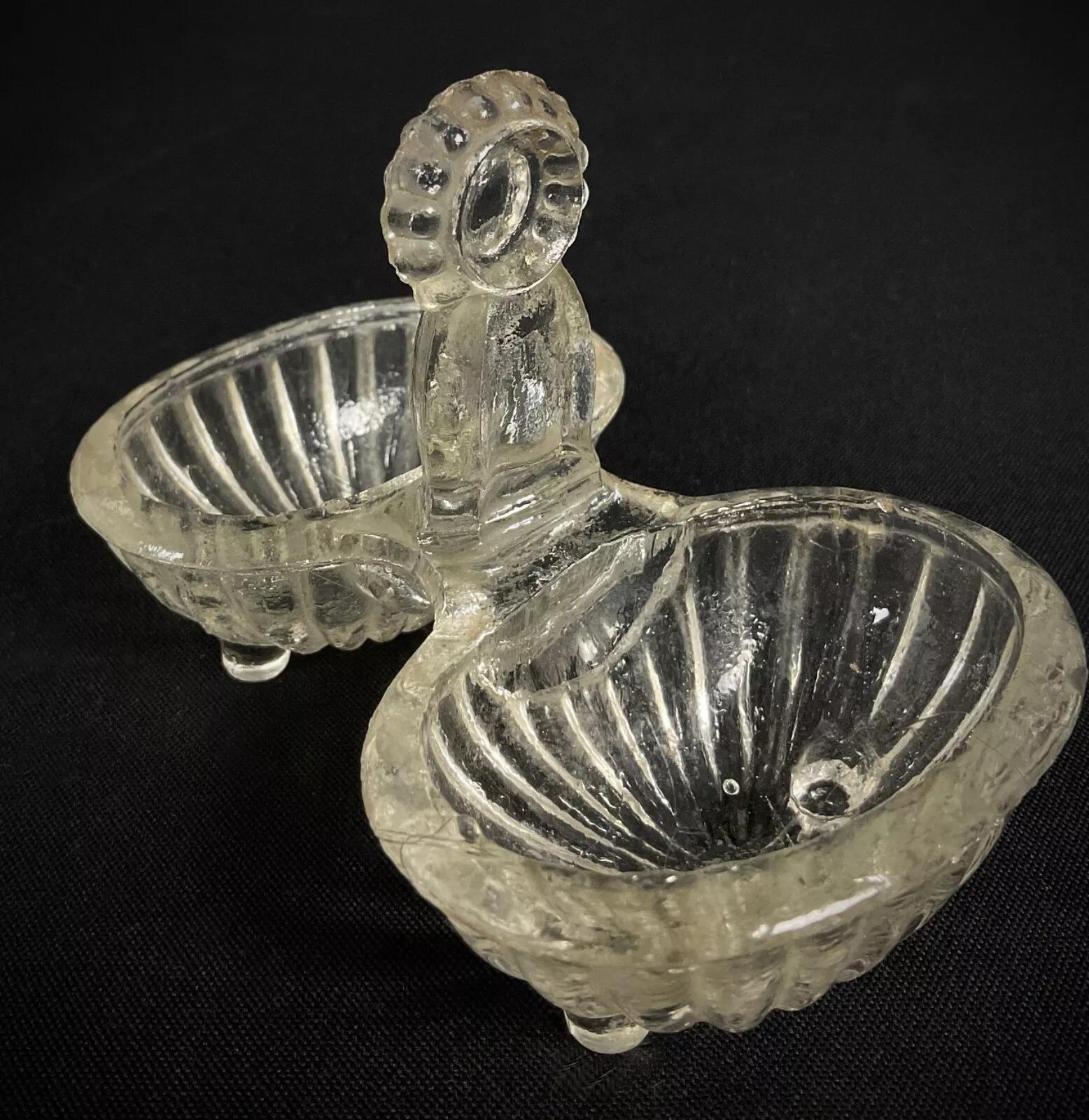 Add a touch of classic French charm to your collection with this antique 20th-century salt cellar, crafted in clear glass and featuring an elegant quadruple-footed design. This unique piece brings both character and function to a table setting or