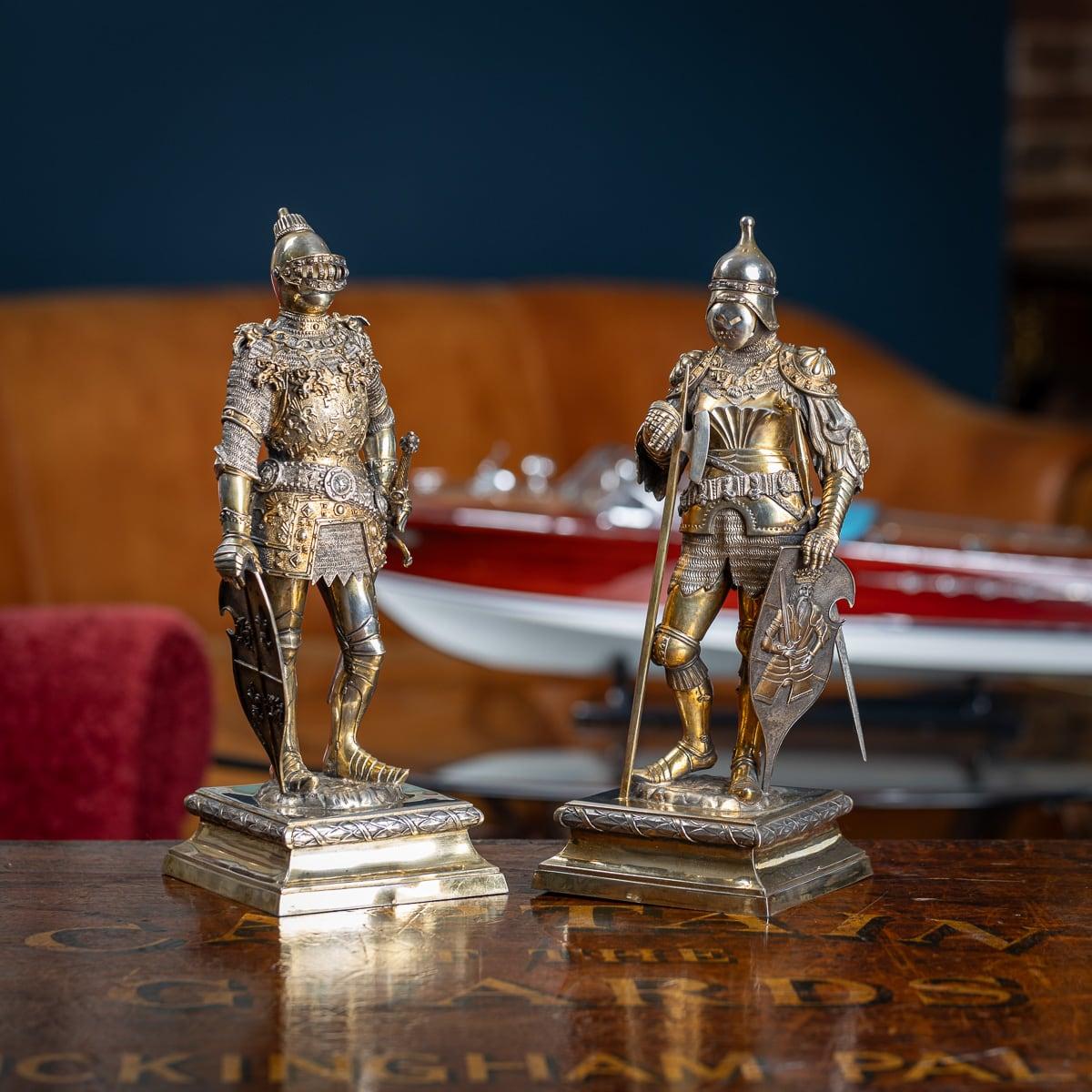Antique early-20th Century pair of exceptionally large and fine German solid silver figures, each modelled as a knight in full suits of armour, carved face beneath a hinged visor, one sporting a sword and the other a spiked axe, both holding a